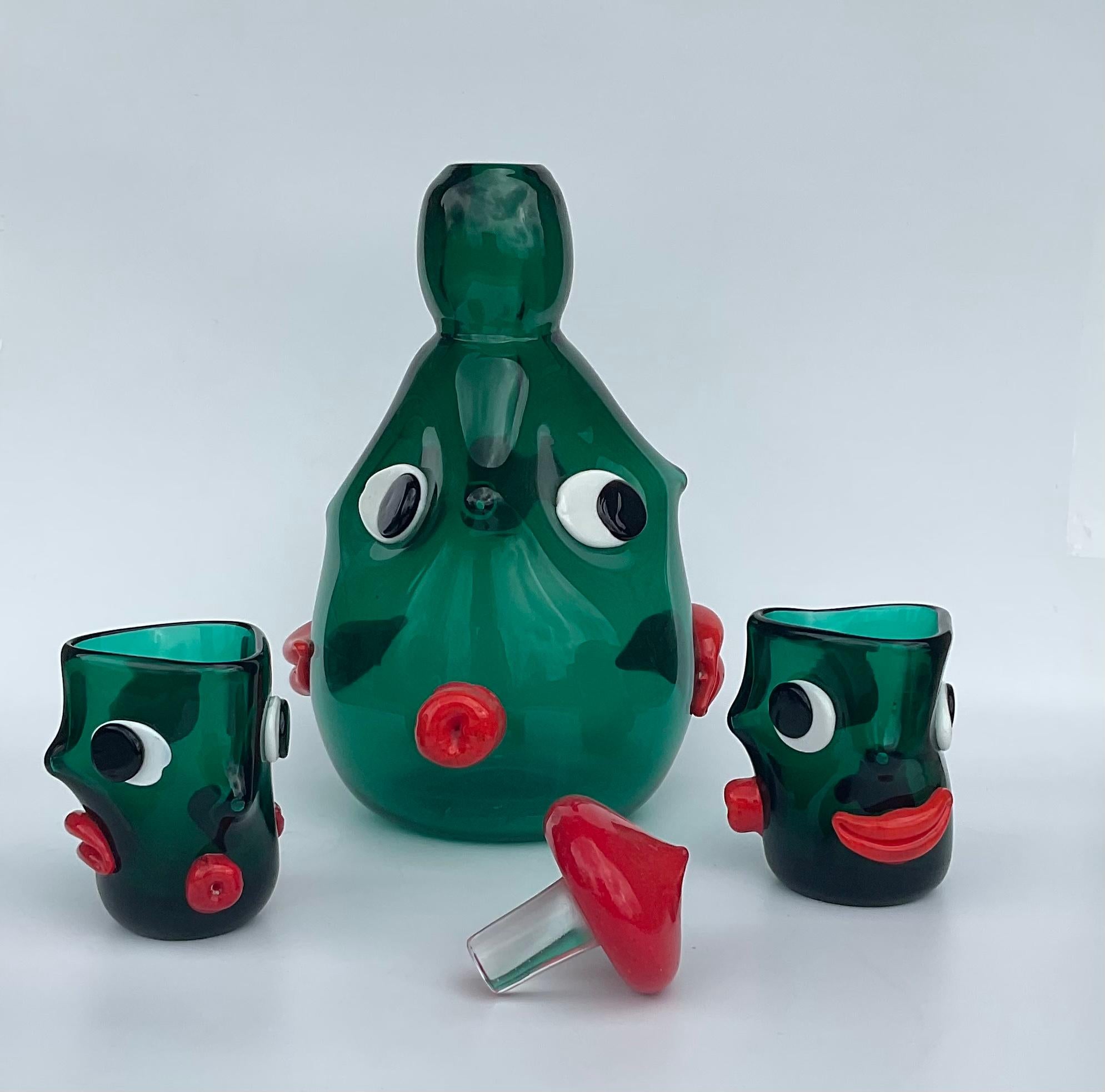 Rare Murano handblown green Italian art glass large decanter with 2 matching glasses done in red applied pasta glass with 3 different faces. Documented to designer Anzolo Fuga. . Similar pieces are described in the Anzolo Fuga book, as In the manner