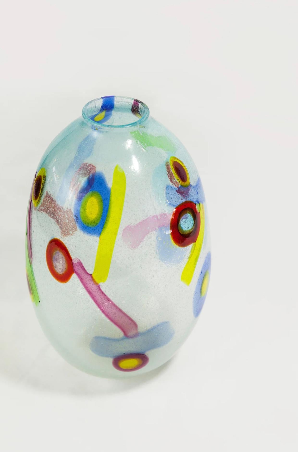 Questo importante vaso di Anzolo Fuga appartiene alla celebre serie delle Murrine Incatenate, creata nel 1960 durante la sua collaborazione con il rinomato laboratorio di Murano A.VE.M. (Arte Vetraria Muranese). Soffiato a mano in vetro di Murano,