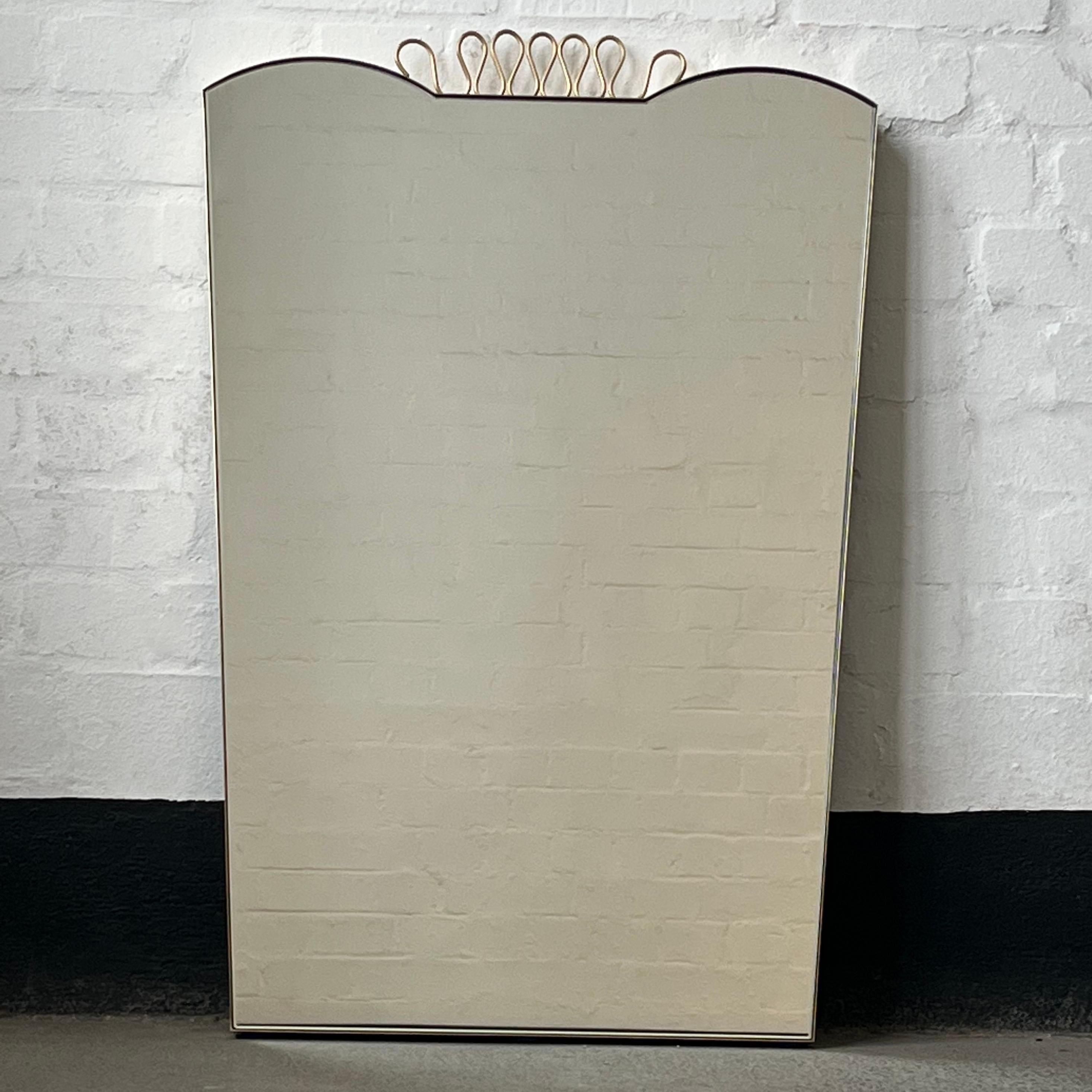Exquisiter Spiegel mit minimalistischem Messingrahmen und geschwungenen dekorativen Details, inspiriert von der berühmten Arbeit des italienischen Designers Gio Ponti. Handgefertigt in London, UK, nach sehr hohen Qualitätsstandards aus reinem,