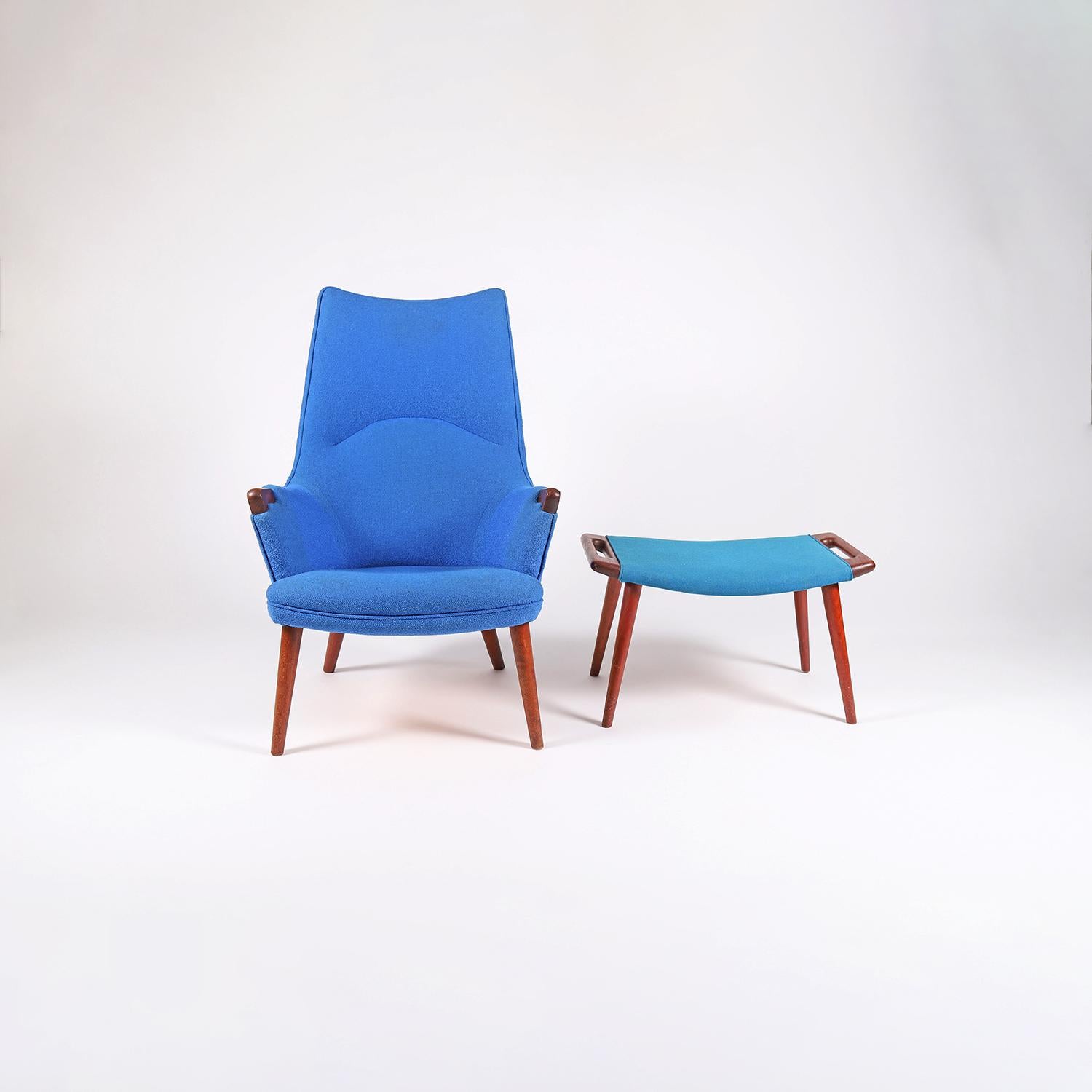 A rare variant Hans J. Wegner designed high back AP27 lounge and AP29 ottoman. Smaller teak hand rest with teak legs on both the lounge and ottoman. Upholstery is in vintage usable condition, please note that the blue wools on the ottoman vs the
