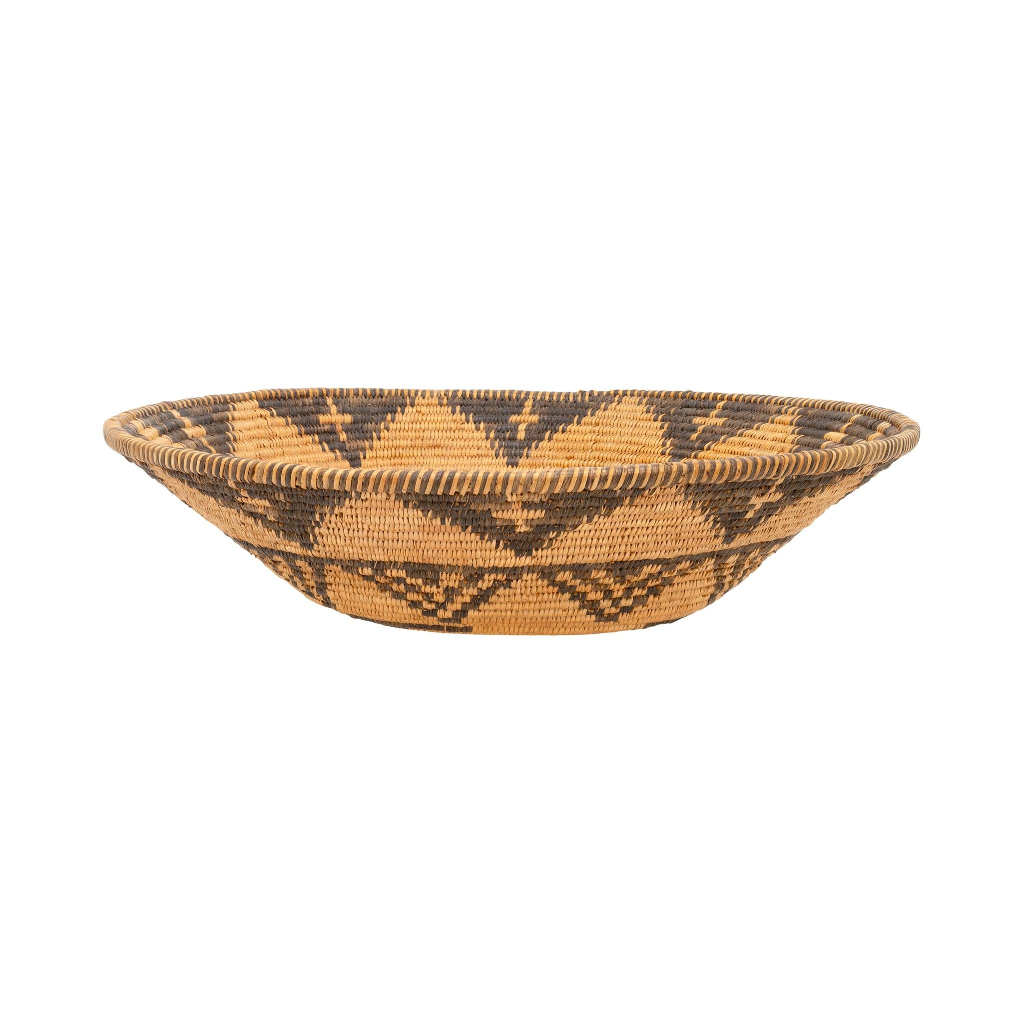 Native American Apache Indian basketry tray. This basket features beautiful golden patina with exceptional old geometric designs having chevron shapes, crosses, and swirls. Well-made and highly displayable. Would complement any handmade indigenous