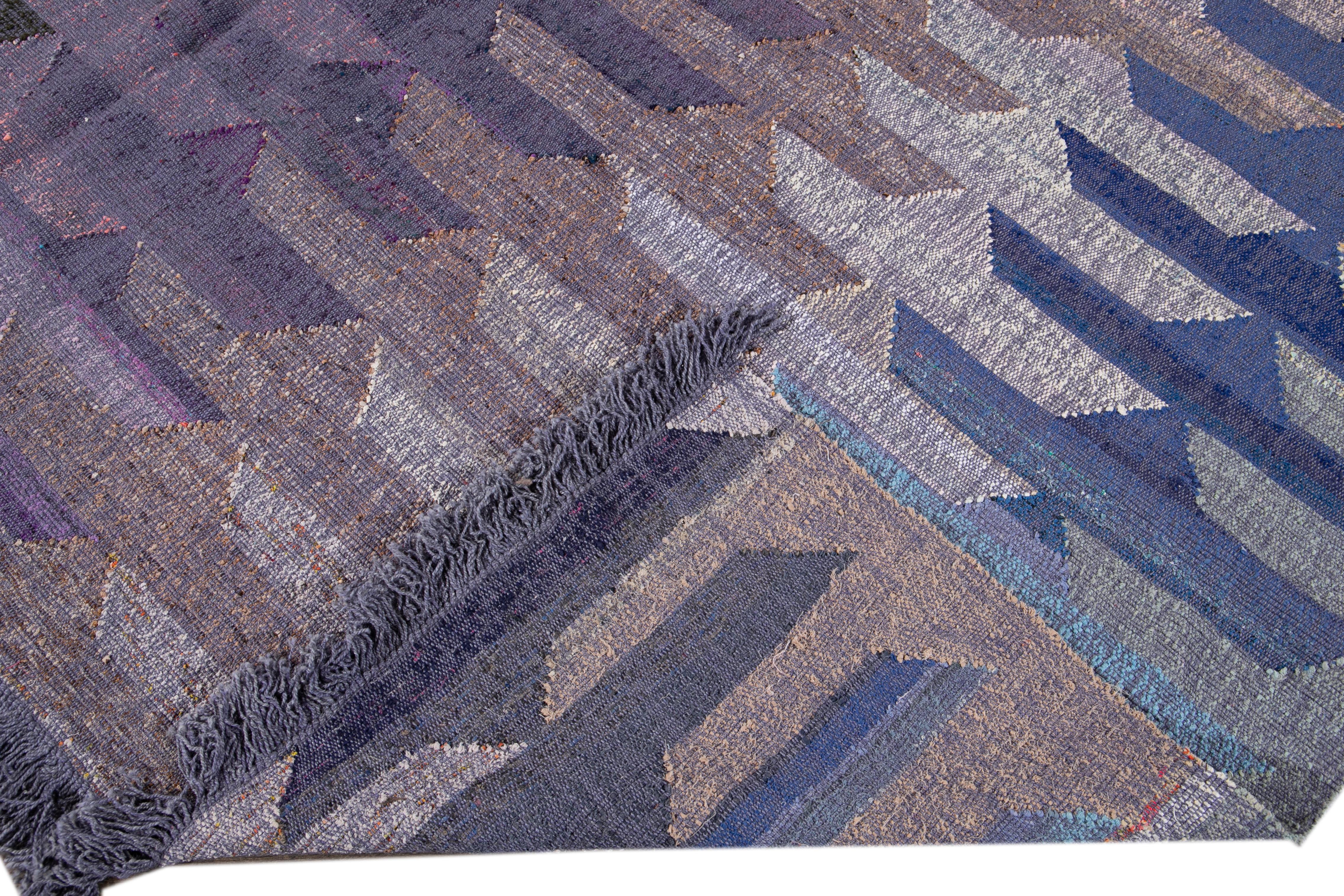 Beautiful modern Kilim flat-weave wool rug with a purple field. This piece of art has blue, green, and yellow accents in a gorgeous geometric abstract design.

This rug measures: 10' x 13'3