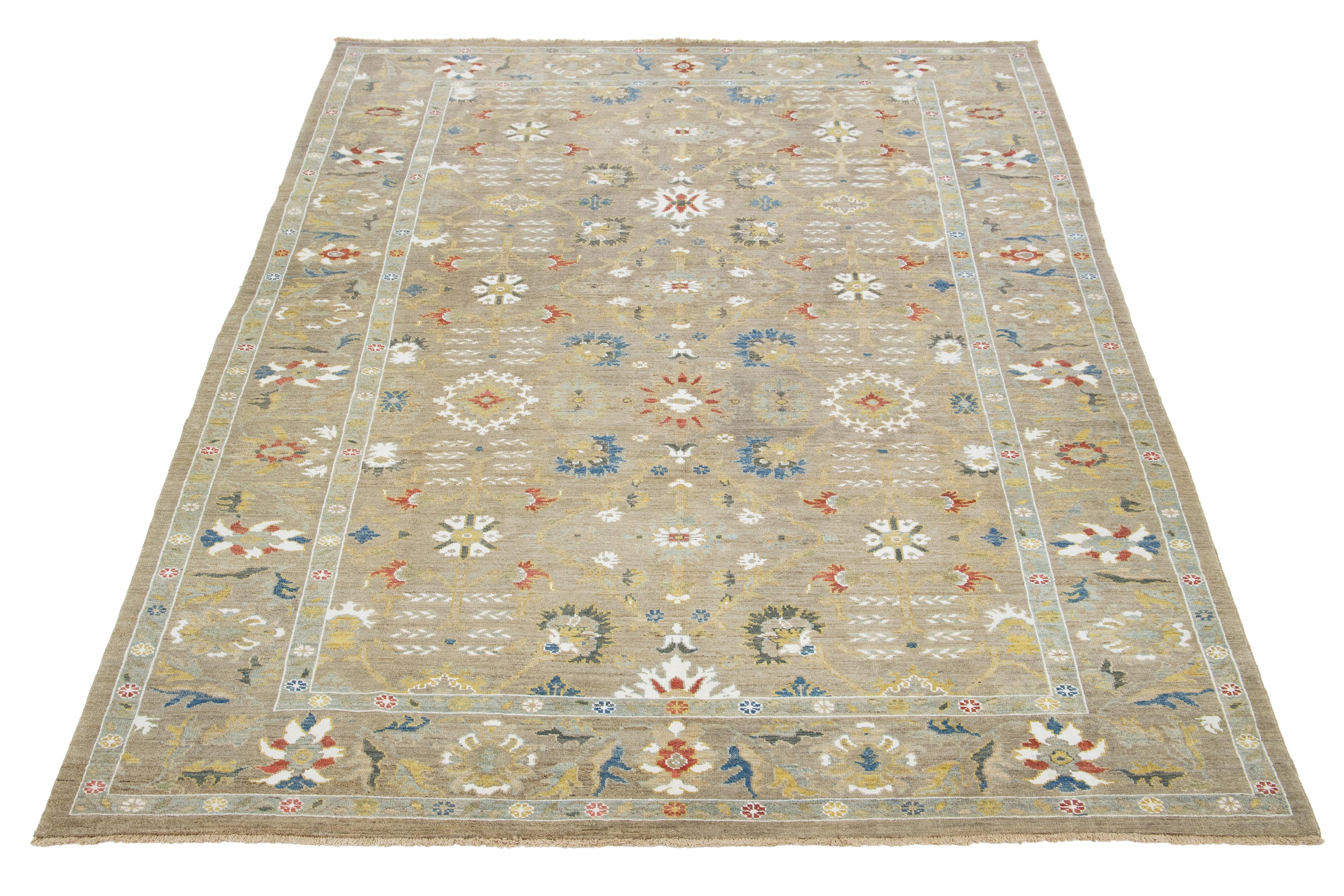 Questo tappeto in lana annodato a mano ha uno sfondo beige ornato da accenti multicolore in un disegno all-over.

Questo tappeto misura 8'9'' x 12'1''. 