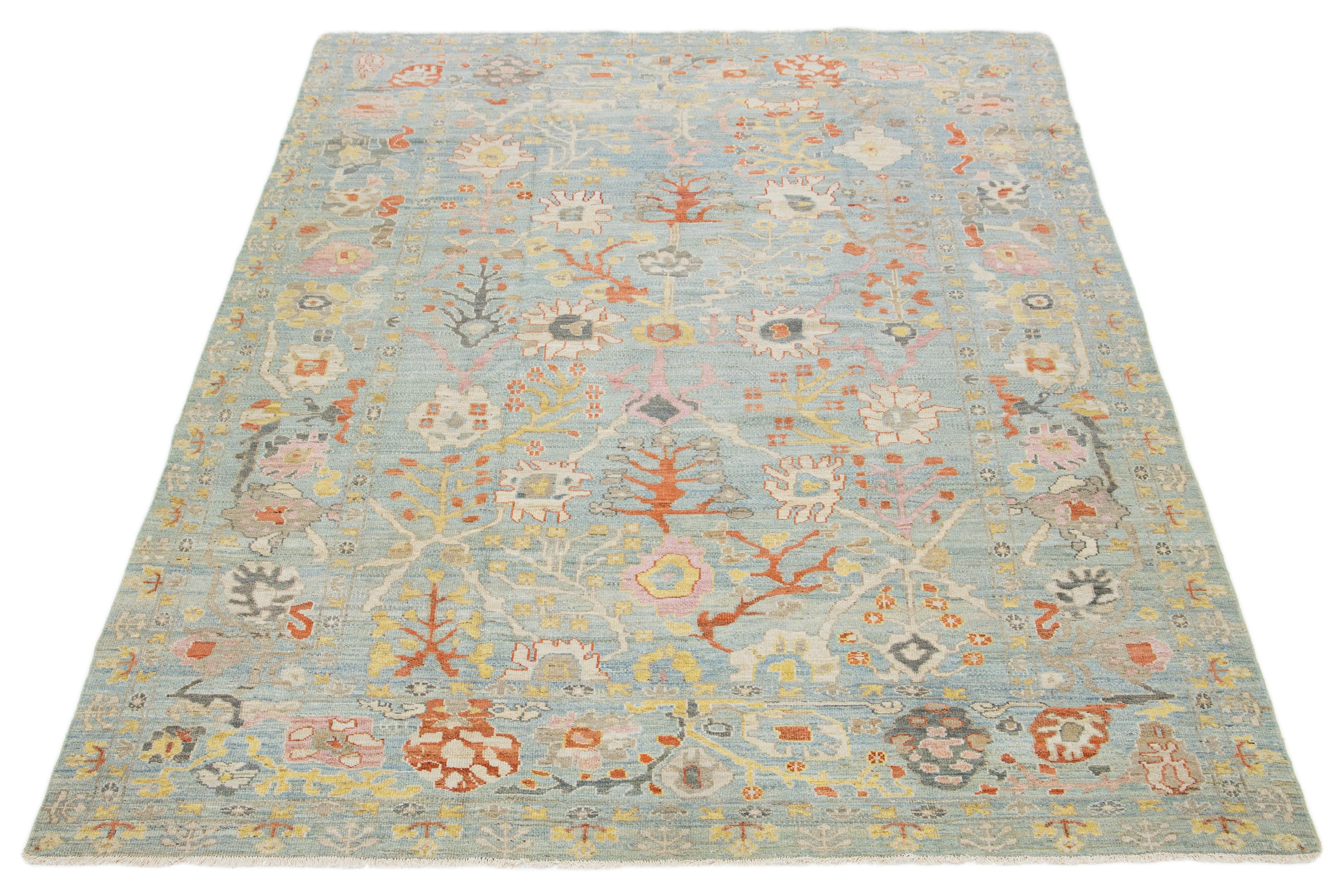 Dieser handgeknüpfte Wollteppich hat einen hellblauen Hintergrund, der mit mehrfarbigen Allover-Motiven verziert ist.

Dieser Teppich misst 8'8'' x 12'2''.
