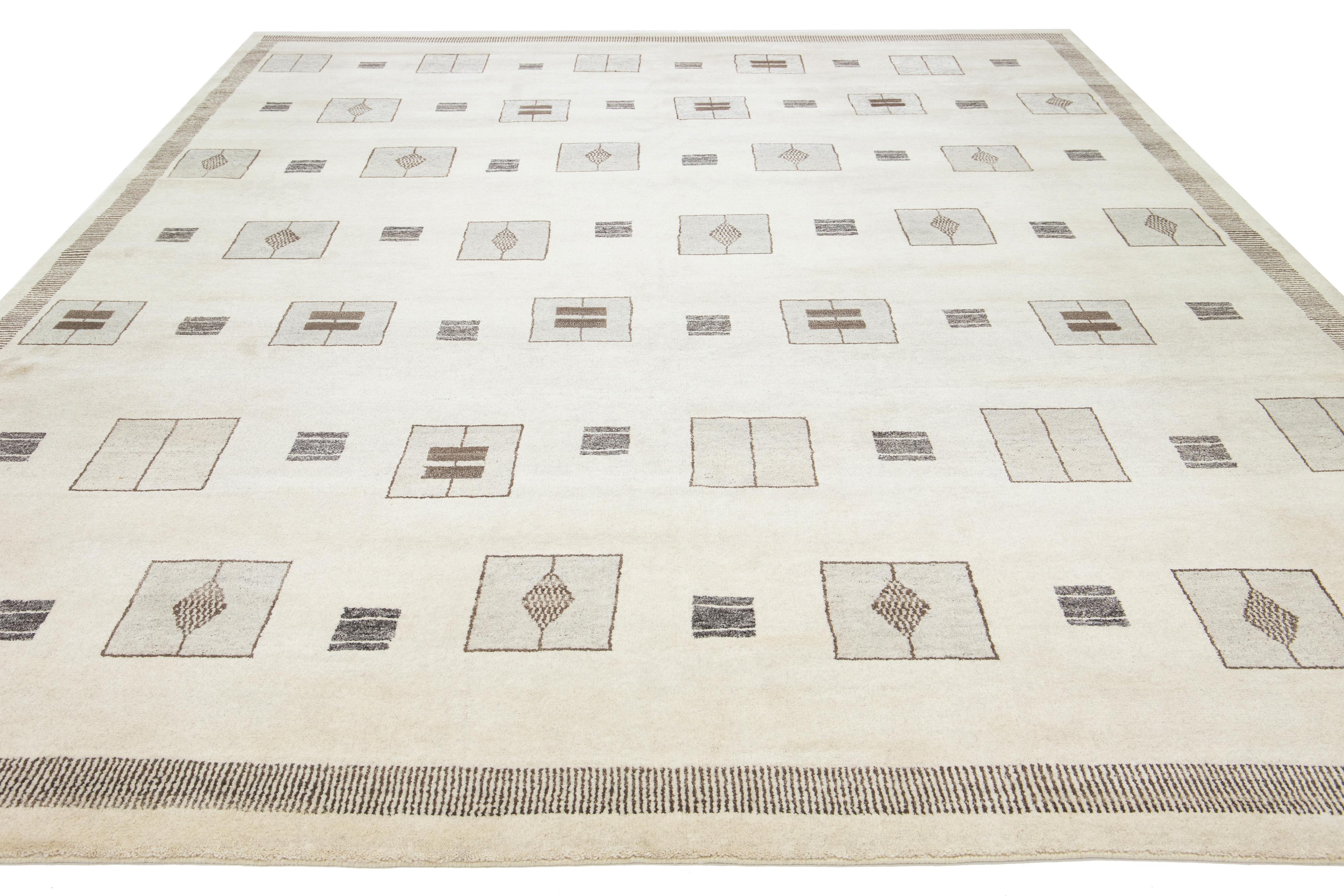 Dieser schöne, moderne, handgeknüpfte Wollteppich im marokkanischen Stil hat ein natürliches, beiges Feld. Sie ist Teil der Safi Collection'S von Apadana und zeigt ein graues und hellbraunes geometrisches Muster.

Dieser Teppich misst 12' x