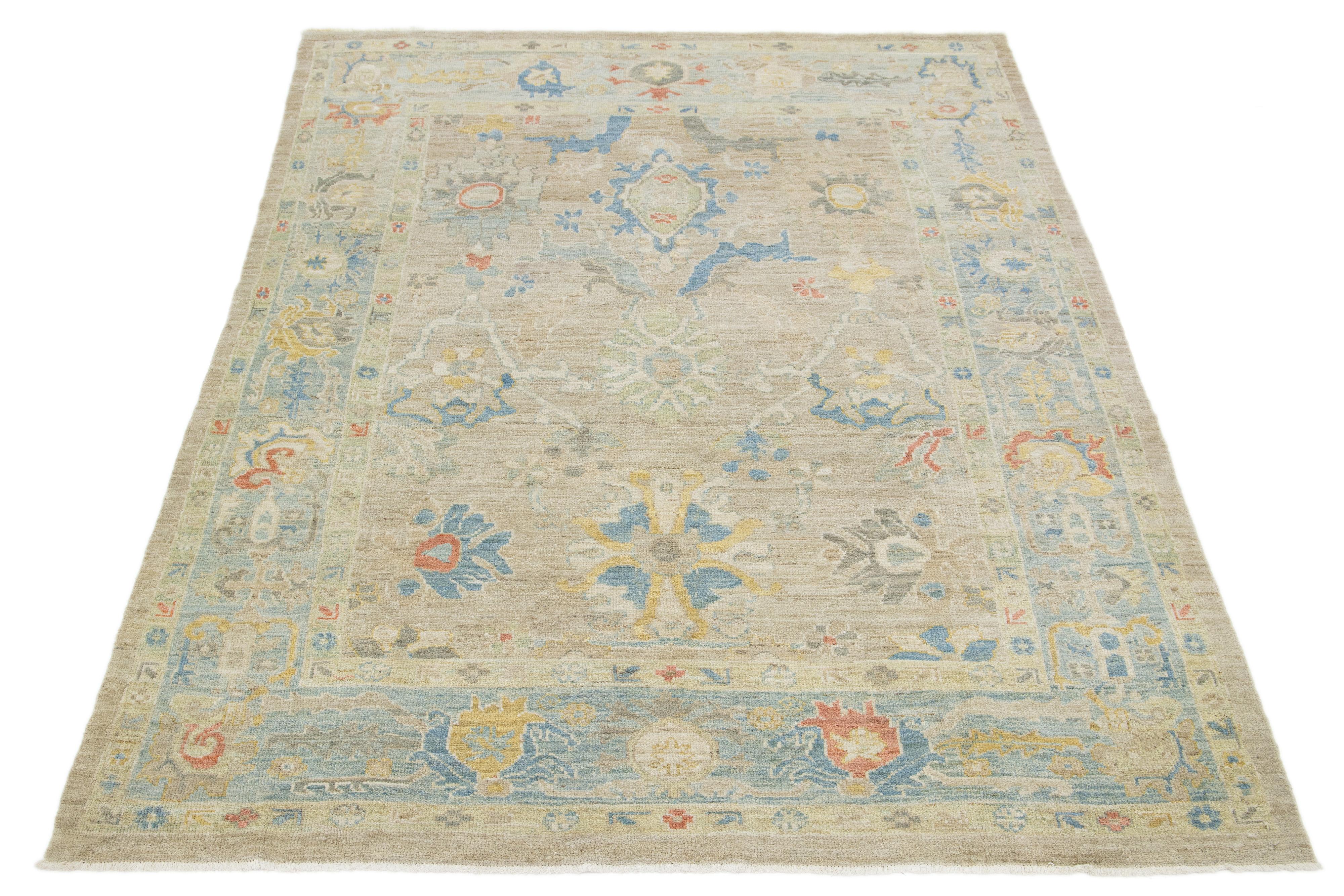 Questo tappeto in lana annodato a mano ha uno sfondo azzurro e una cornice blu ornata da accenti multicolore in un disegno all-over.

Questo tappeto misura 6'3'' x 9'.