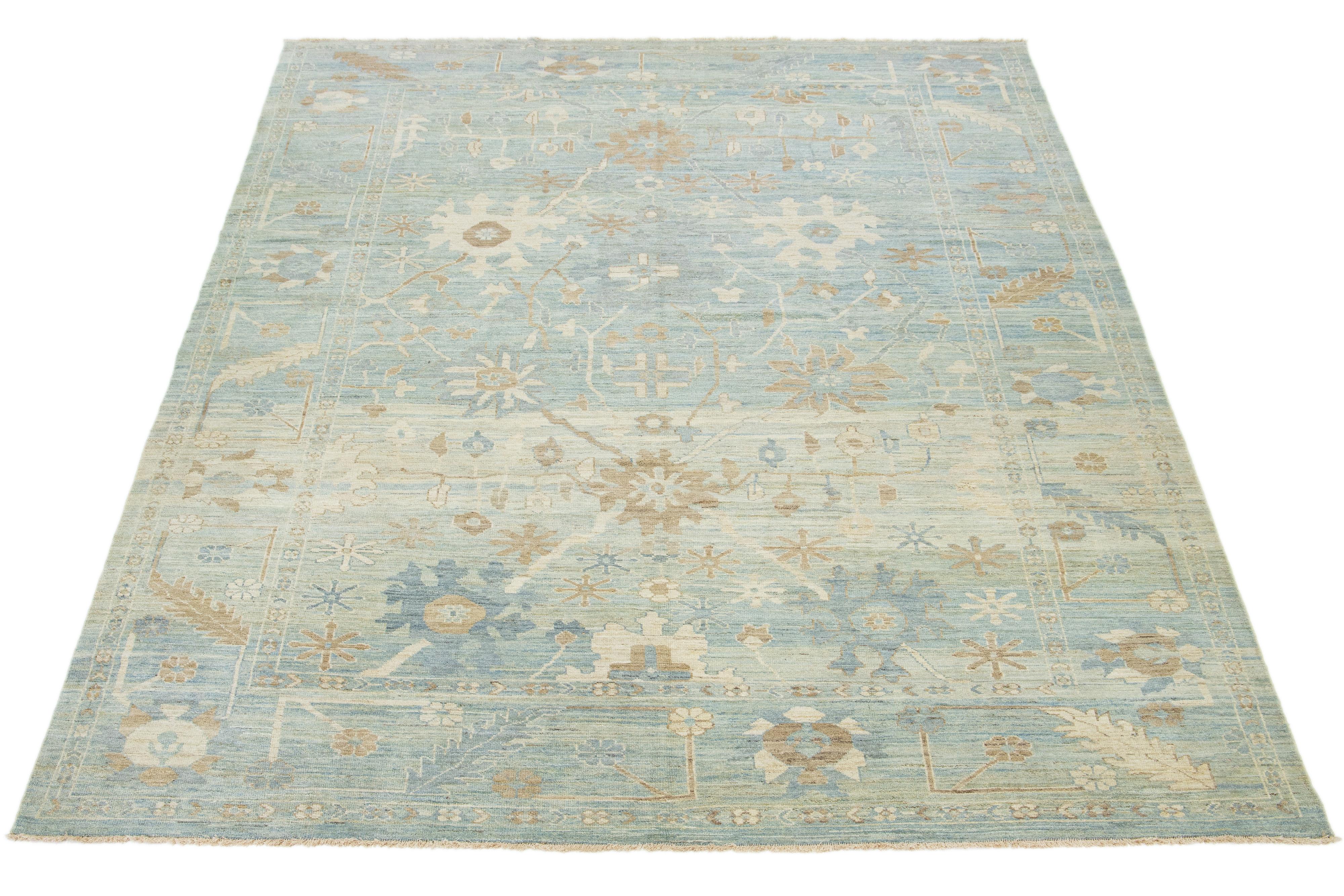Questo tappeto in lana annodato a mano ha uno sfondo blu tenue ornato da un disegno floreale beige-tan.

Questo tappeto misura 10'3'' x 14'.