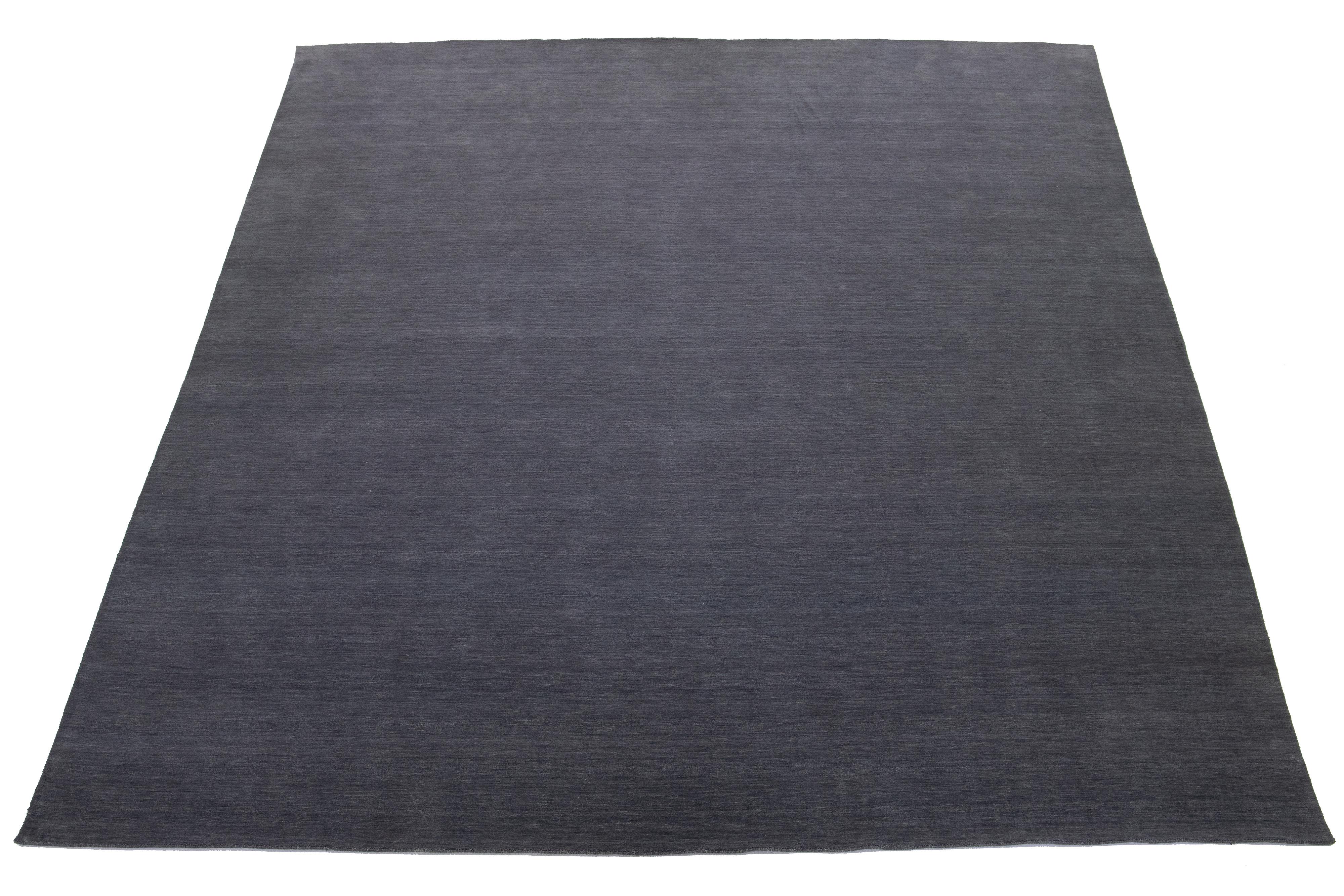 Questo tappeto in lana personalizzato e realizzato a mano, in stile Gabbeh, è caratterizzato da un design a tinta unita di colore grigio. Fa parte della nostra Desert Collection ed è disponibile in diversi colori. Utilizziamo tecniche di lavorazione