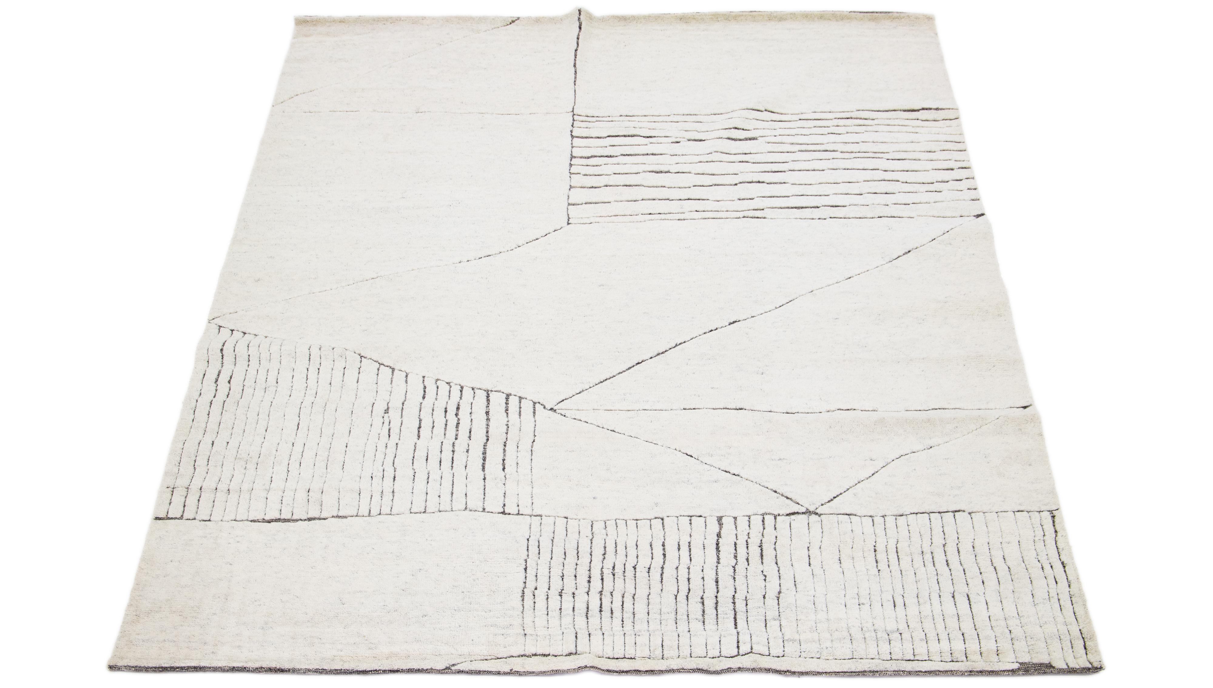 This luxurious wool rug features a timeless Moroccan pattern in a contemporary abstract Minimalist style, utilizing beige tones to create a sleek and modern look. It is crafted using traditional hand-knotting techniques, ensuring exceptional quality