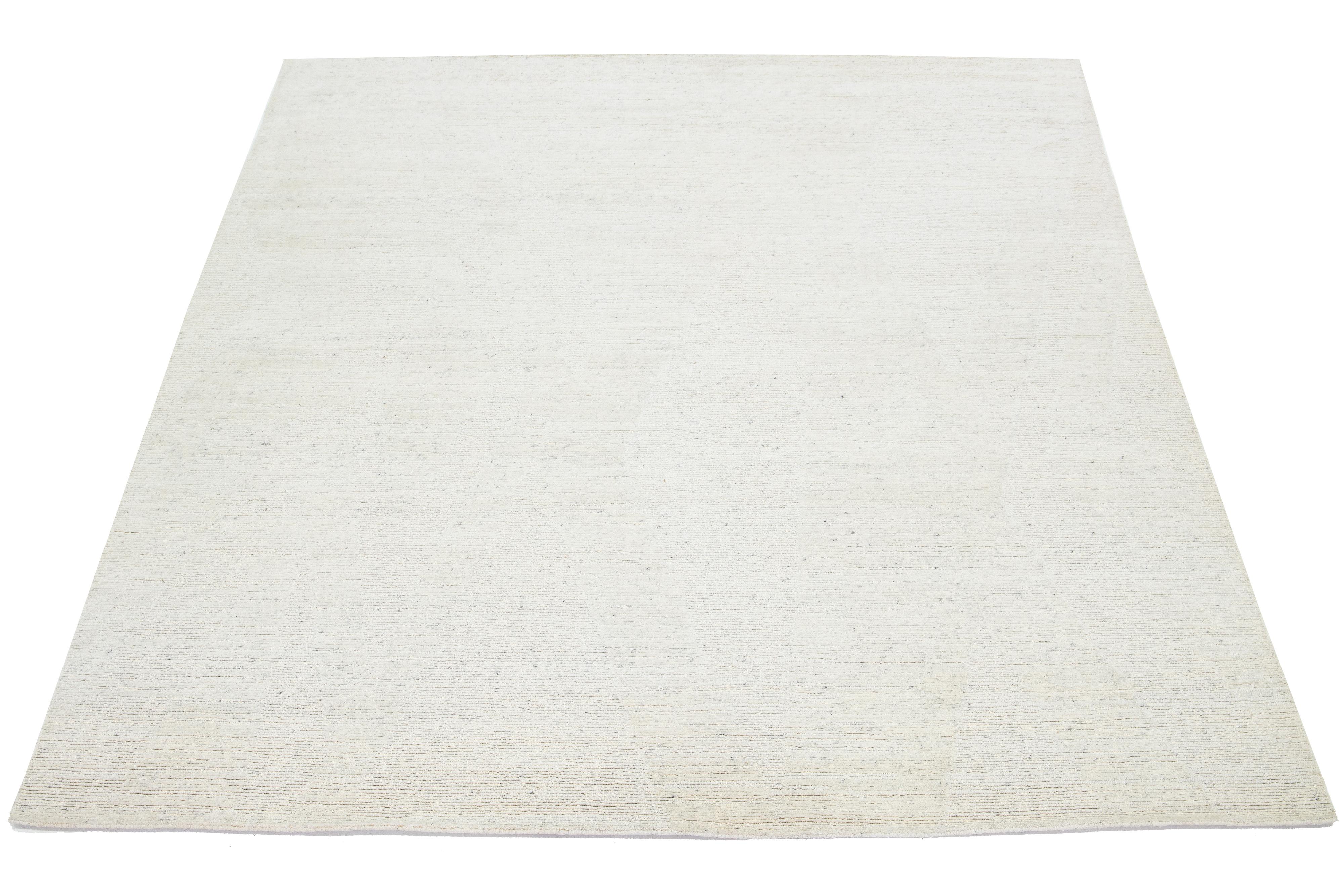 This hand-knotted Moroccan-style rug is made from wool and showcases a captivating minimalist aesthetic. It features a naturally hued ivory background.

This rug measures 8' x 10'.