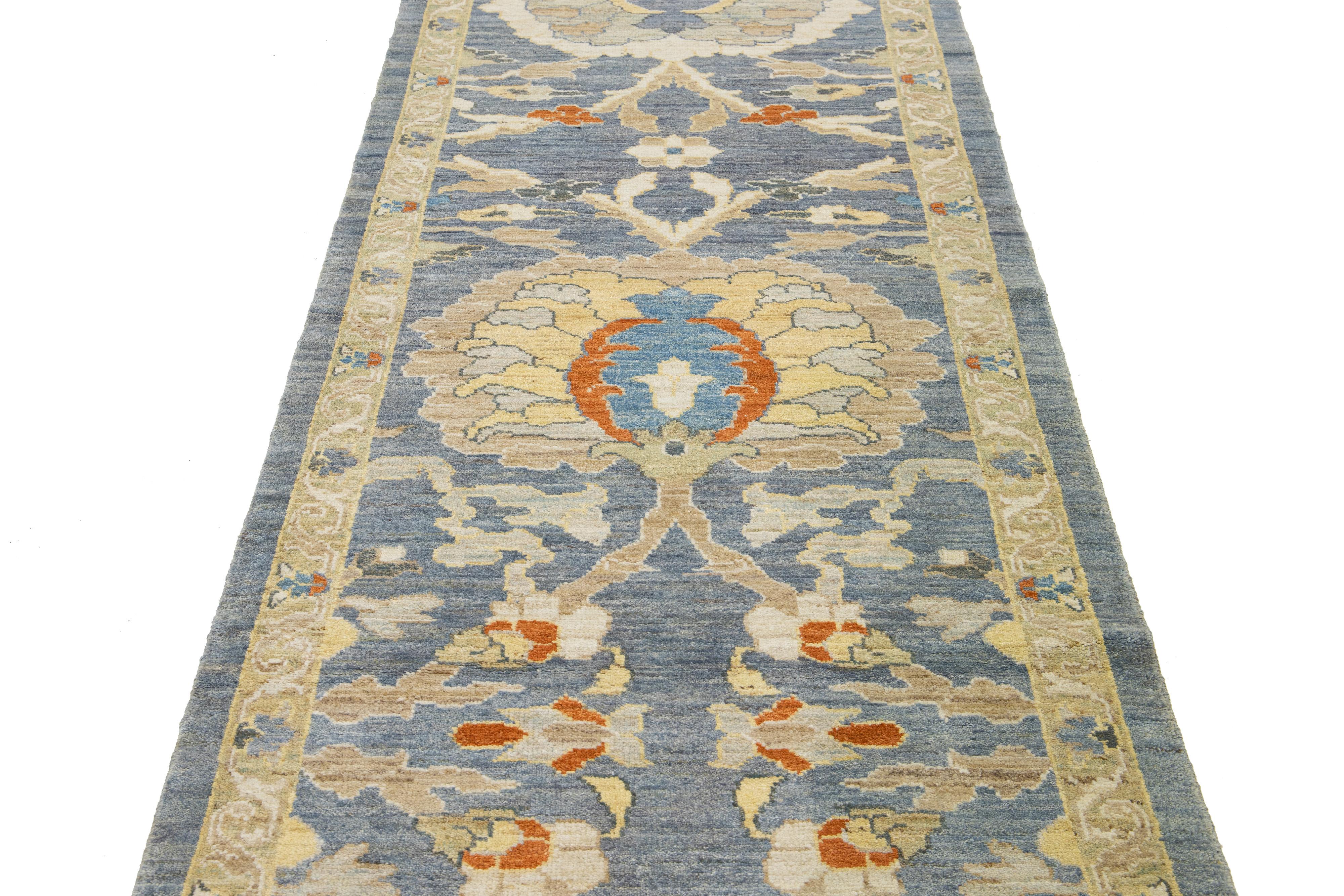 Dieser handgeknüpfte Wollteppich hat einen blauen Hintergrund, der mit einem mehrfarbigen Allover-Muster verziert ist.

Dieser Teppich misst 3'5'' x 34'6