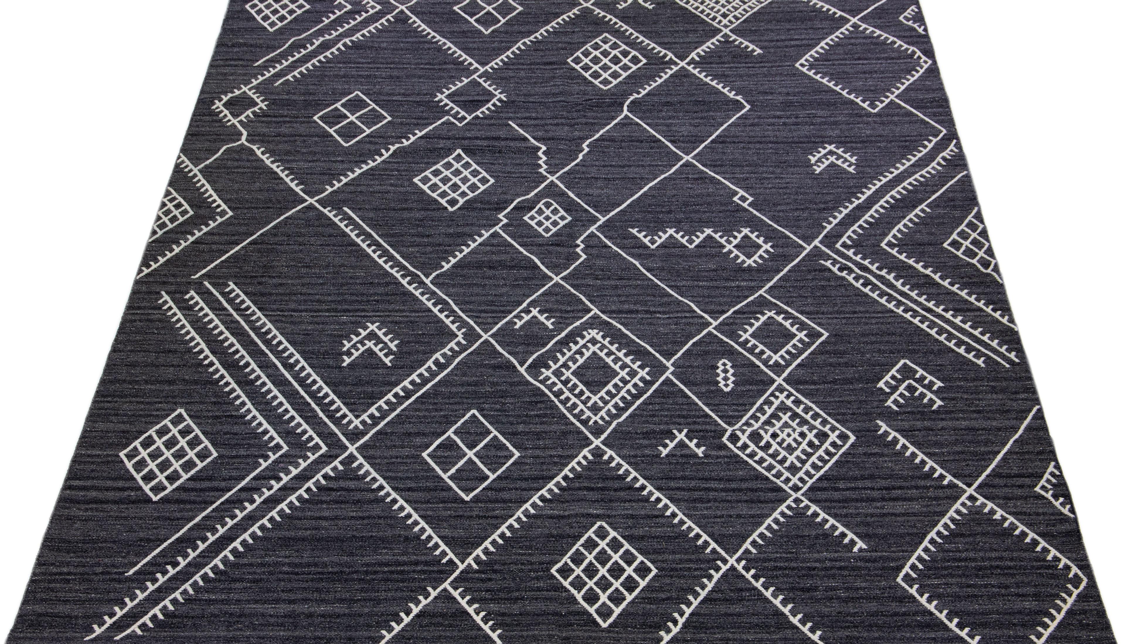 Beautiful kilim handmade wool rug with a gray-charcoal field. This custom modern flatweave rug of our Nantucket collection has white accents and a gorgeous, all-over geometric coastal design.

This rug measures: 10'2