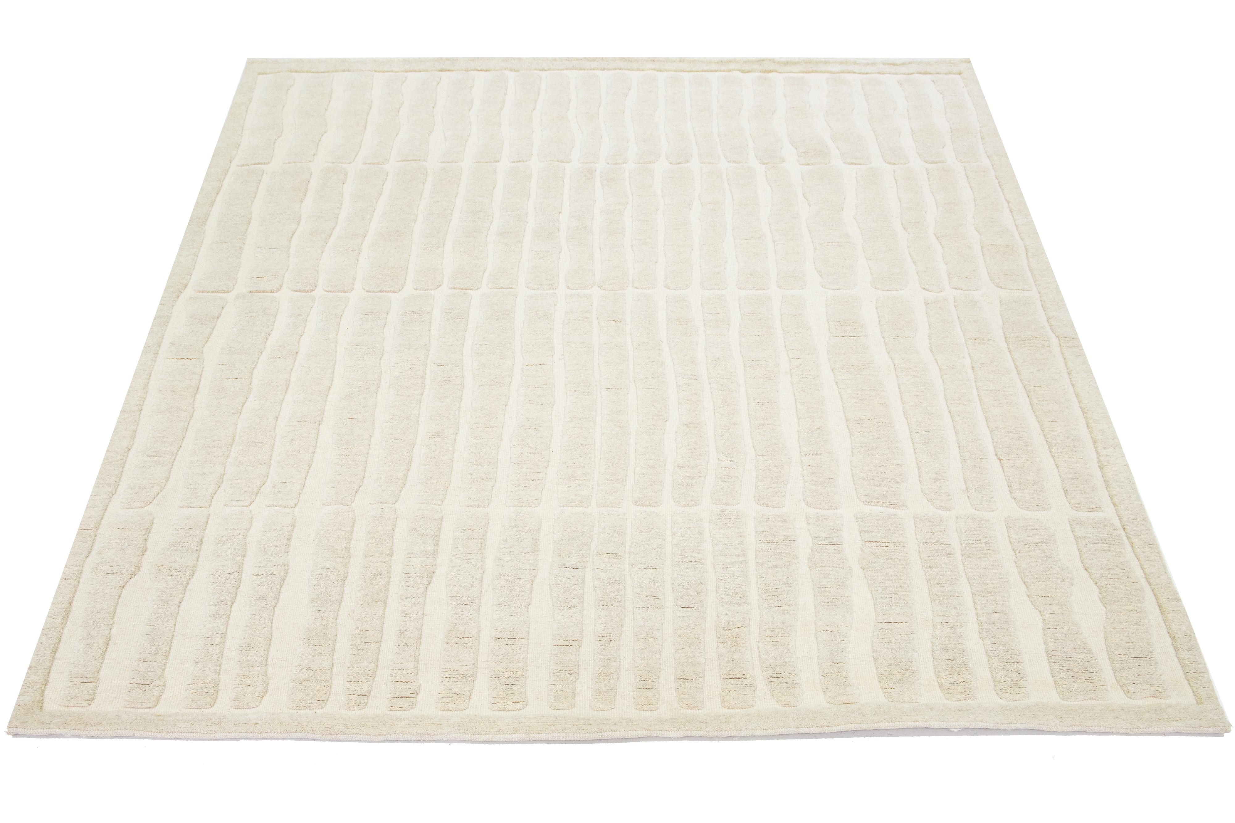 This Moroccan-style wool rug is hand-knotted and showcases a beautiful modern design with a natural ivory field. It features a stunning geometric pattern.

This rug measures 8'2