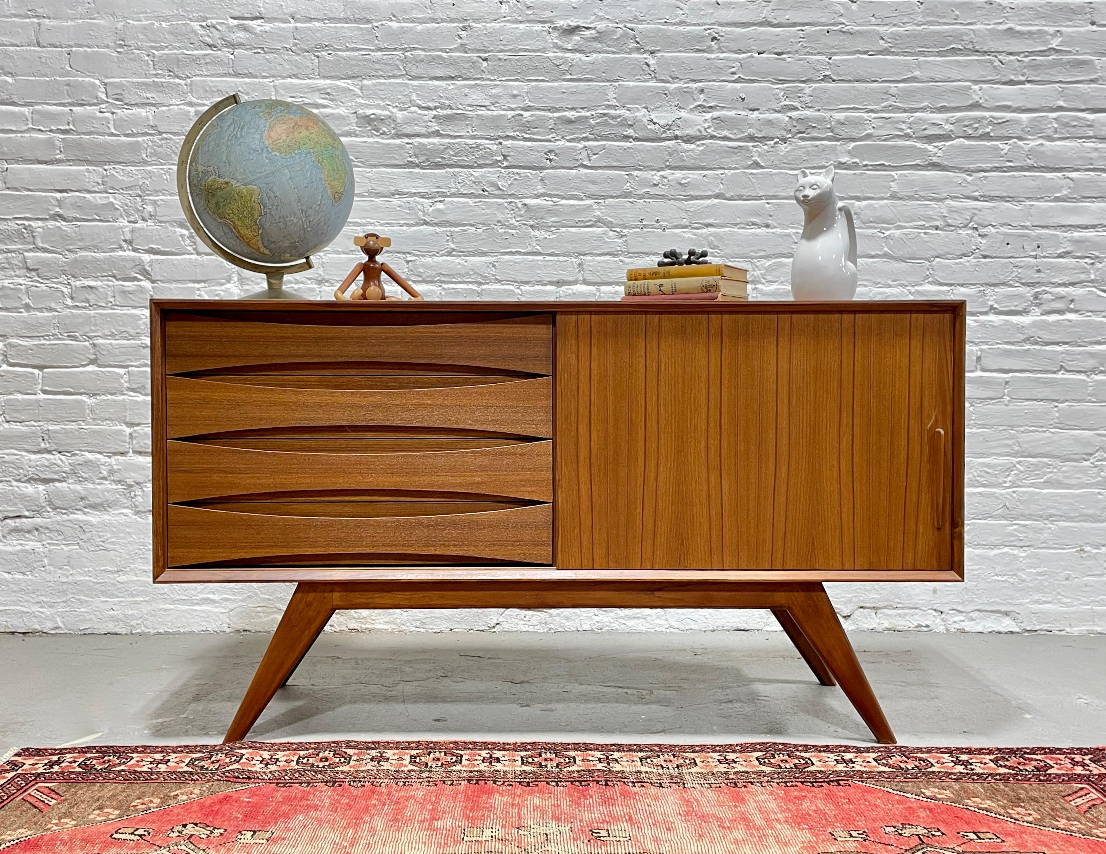 Perfect smaller sized Mid Century styled credenza / media stand with superb splayed leg design. Thoughtful layout for a media stand - shelving for components along one side and streamlined drawers for remotes, dvds and other accessories. The funky