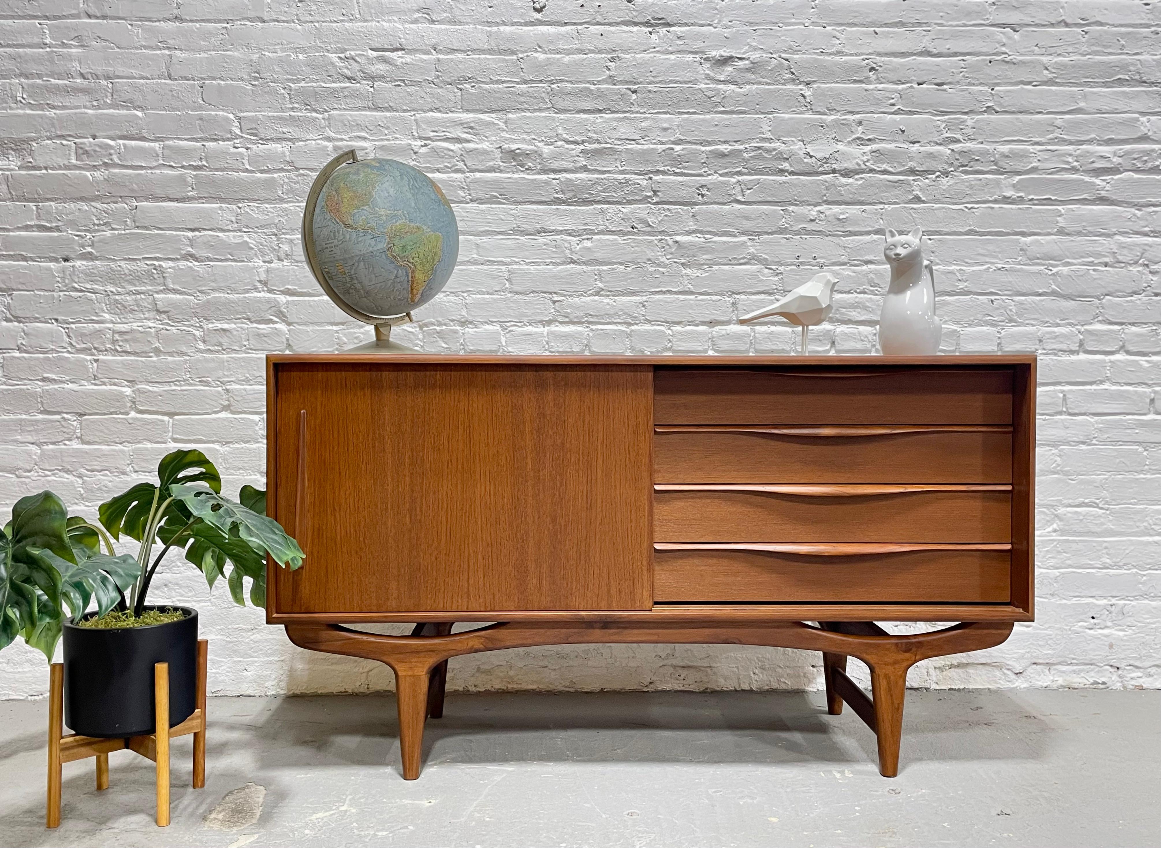 Mid Century Modern styled Handmade Credenza / Media Stand in a perfectly tailored apartment size. This beauty features exquisite sculptural hand pulls and bowtie leg design and is a handmade, newly built piece made from reclaimed teak. Stunning wood