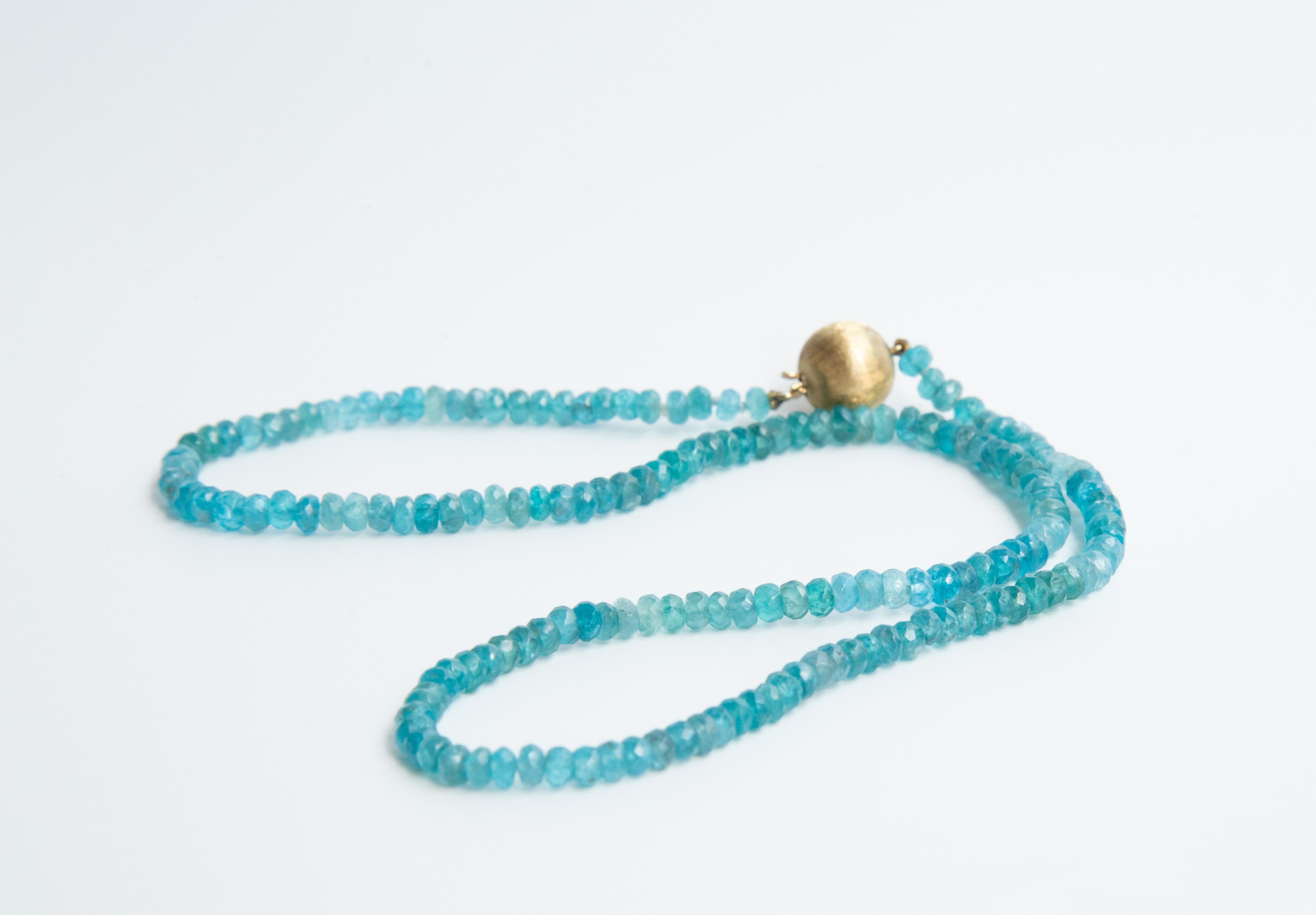 A vintage beaded necklace made of genuine faceted round apatite beads (diameter 4 mm) in vivid blue. The necklace features a 14 karat yellow gold ball lock (11 mm).  The weight of the necklace is 14.5 grams and the total length is 45 cm. The