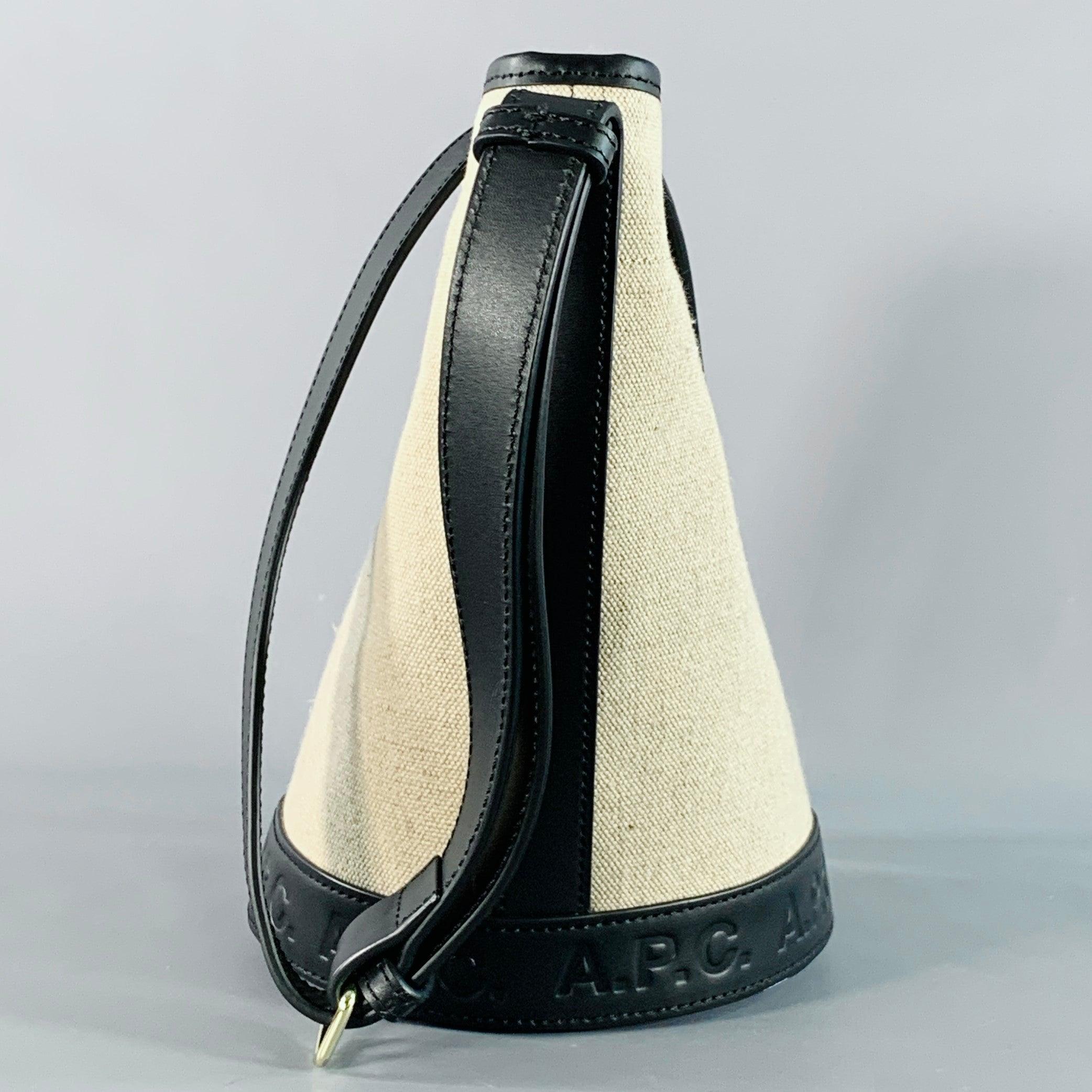 Borsa A.P.C.
in misto juta e cotone beige con finiture in pelle di mucca nera, con stile a secchiello, tracolla regolabile e chiusura a scatto. Viene fornito con un sacchetto antipolvere.Eccellente condizione di usato. 

Misure: 
  Lunghezza: 6,5