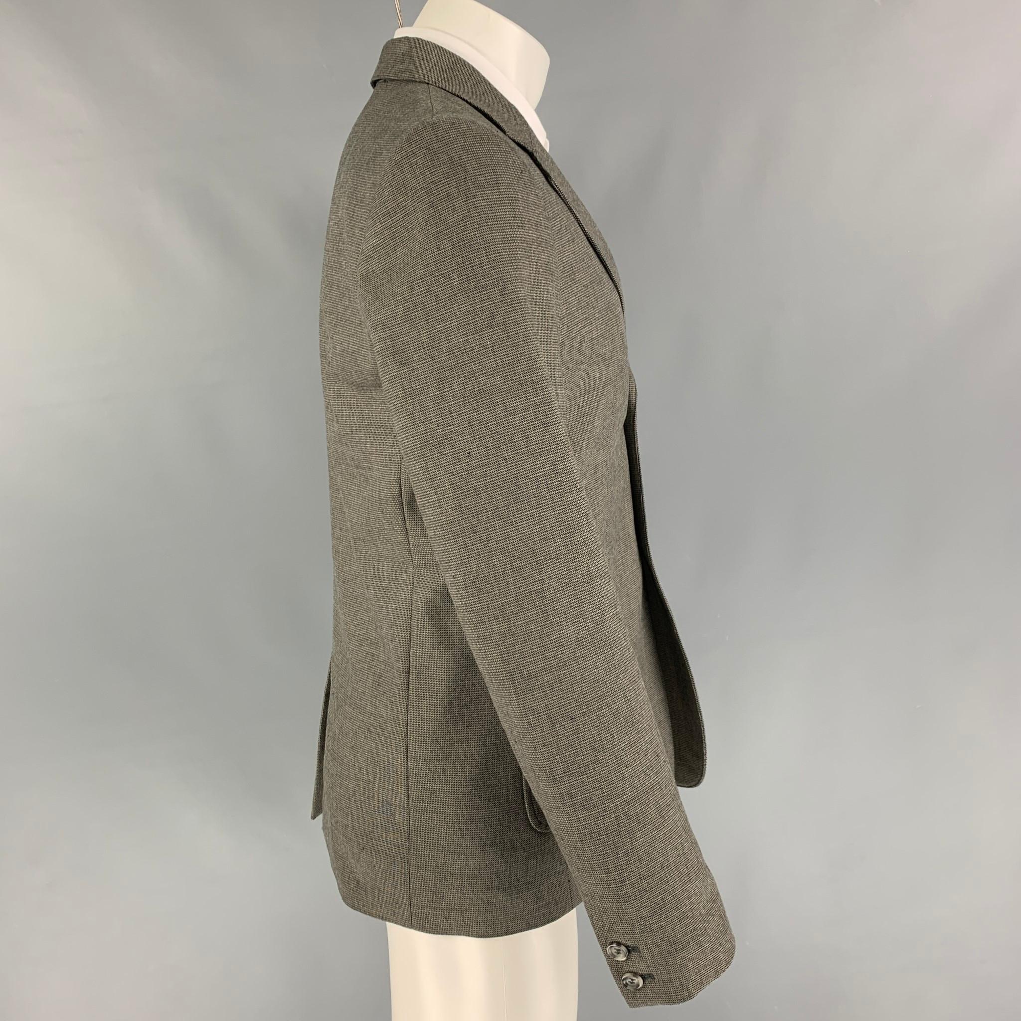 A.P.C sport coat comes in a grey & cream wool with a full liner featuring a notch lapel, patch pockets, single back vent, and a double button closure. 

Very Good Pre-Owned Condition.
Marked: M
Original Retail Price:
