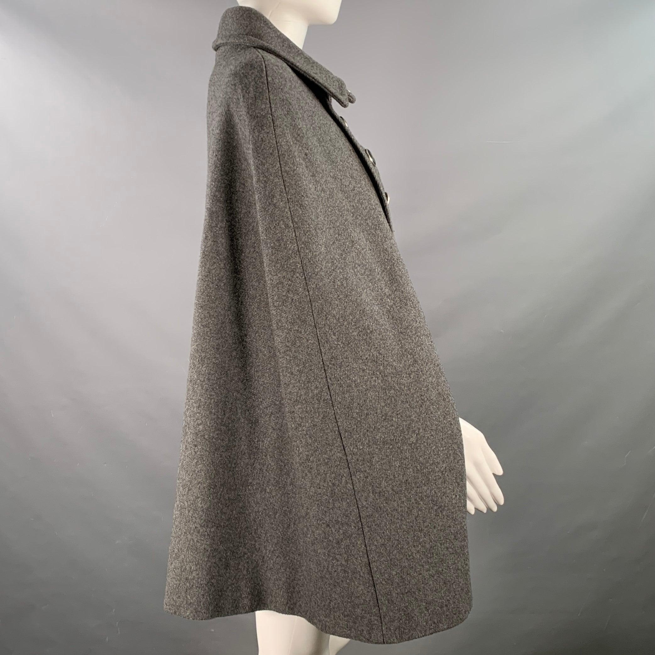 Cape A.P.C.
en sergé gris (semblable à de la laine) avec une double poitrine, une poche kangourou et une fermeture à double bouton.Excellent état d'occasion.
Tags enlevés. 

Marqué :   M 

Mesures : 
 
Épaule : 17.5 pouces Longueur : 30 pouces 
  

