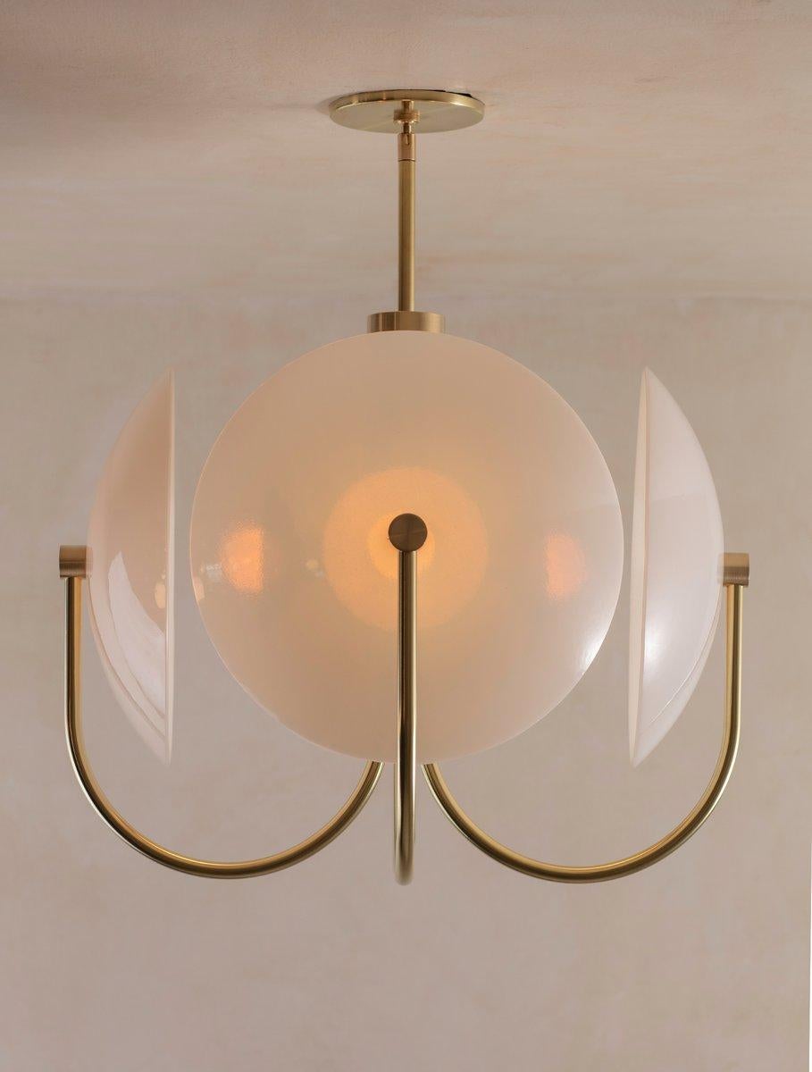 The Aperture series was created to provide a beautiful quality of light by combining bounce and ambient glow. The light source is held in a hand-spun perforated brass dome on one side, while a hand-bent tube arcs around the other; Diffusing and