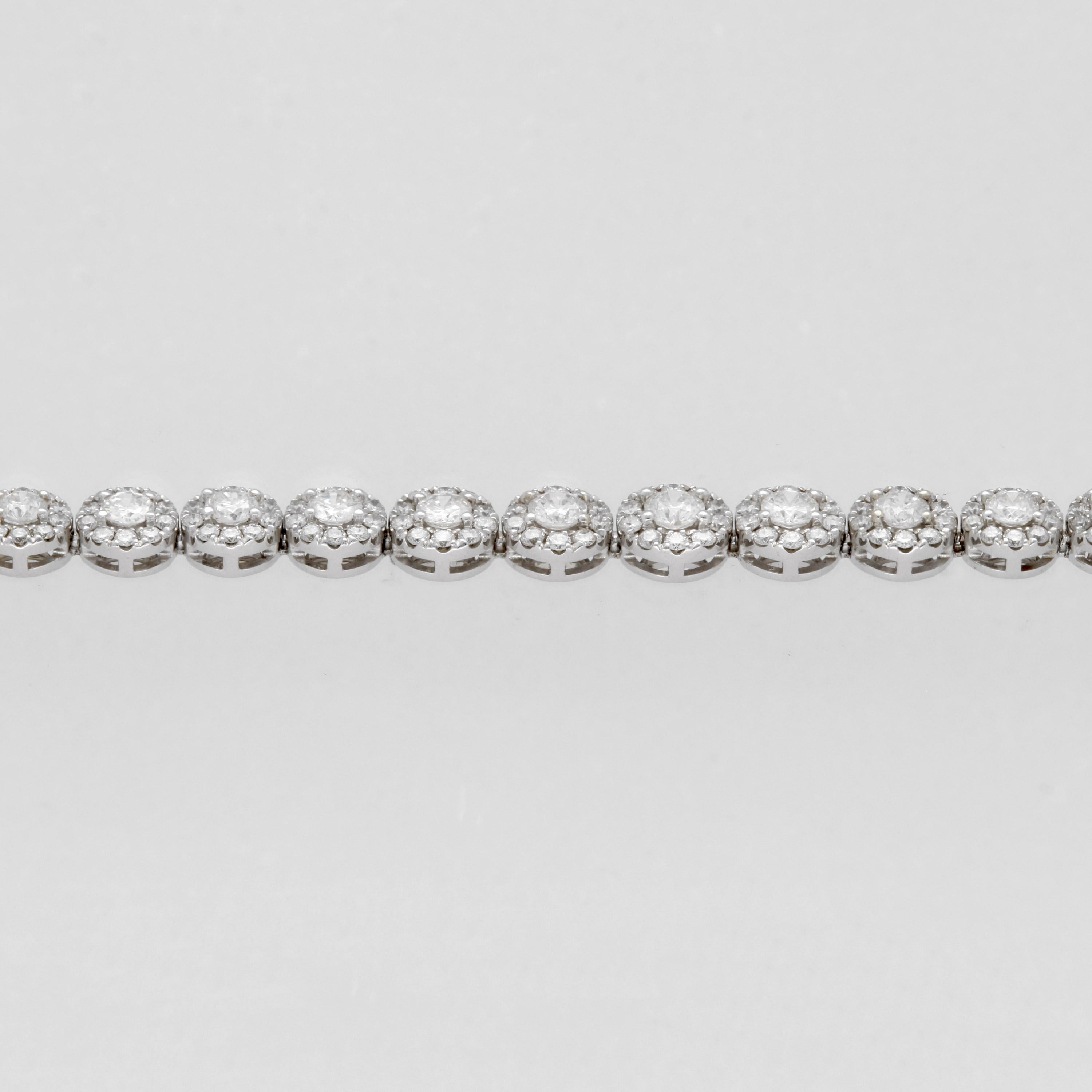 This diamond bracelet is designed by Apex Diamonds and is cast in 14k white gold. It features 6.76 total carat weight of H-I color, SI1 clarity diamonds set in a halo link design. The bracelet is 7 inches in length and is secured by a box clasp.
