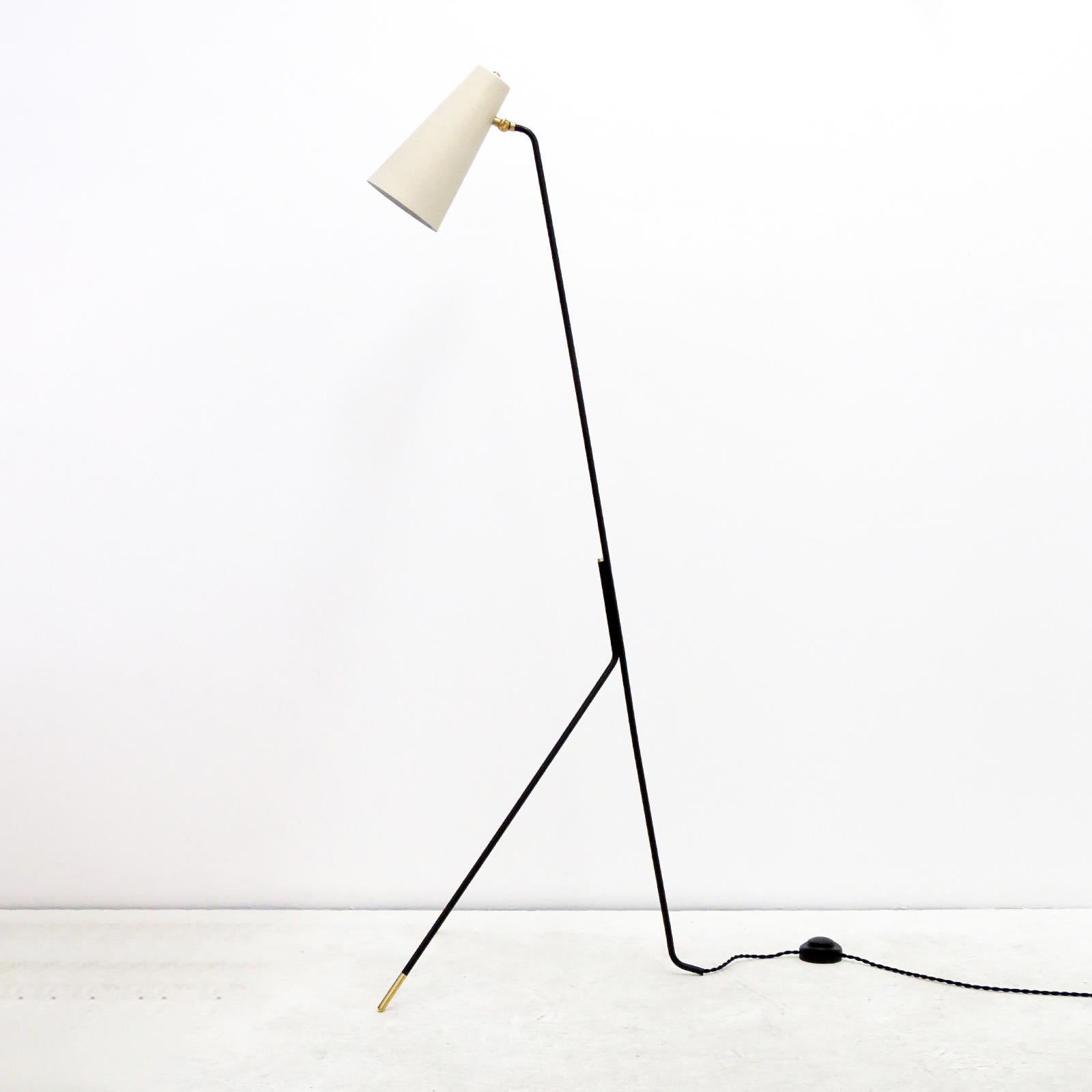 Wonderful minimalist tripod floor lamp by Gallery L7, handcrafted and finished in Los Angeles, black powder coated frame with brass accents and egg shell colored large conical shade. One E26 socket per lamp, max. wattage 75w each or 3-7w LED