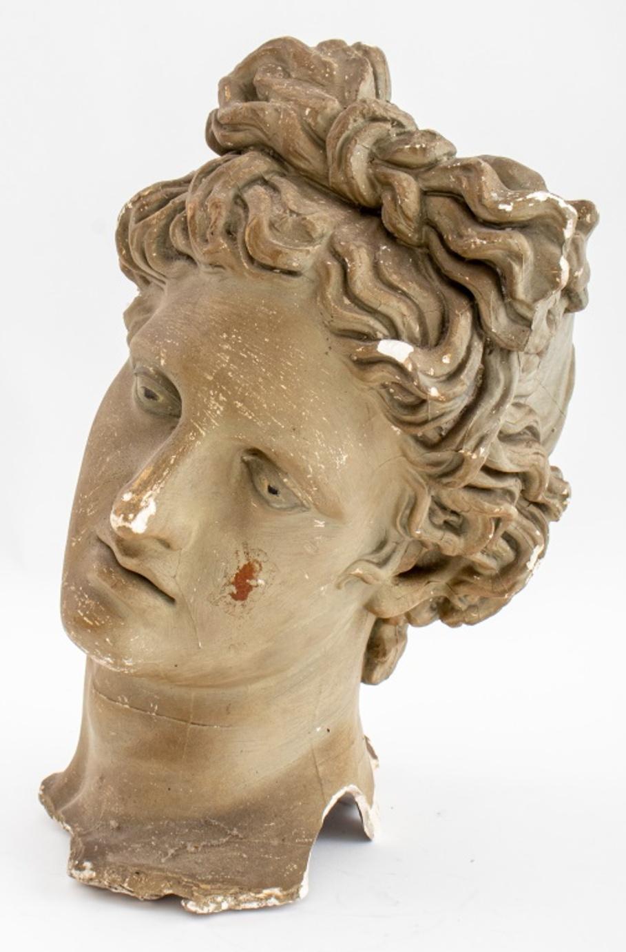 Grand Tour style plaster cast after the head of the Apollo Belvedere, an Hadrianic Roman sculpture in the Hellenistic style, the cast illegibly signed to base.

Dimensions: 16.5