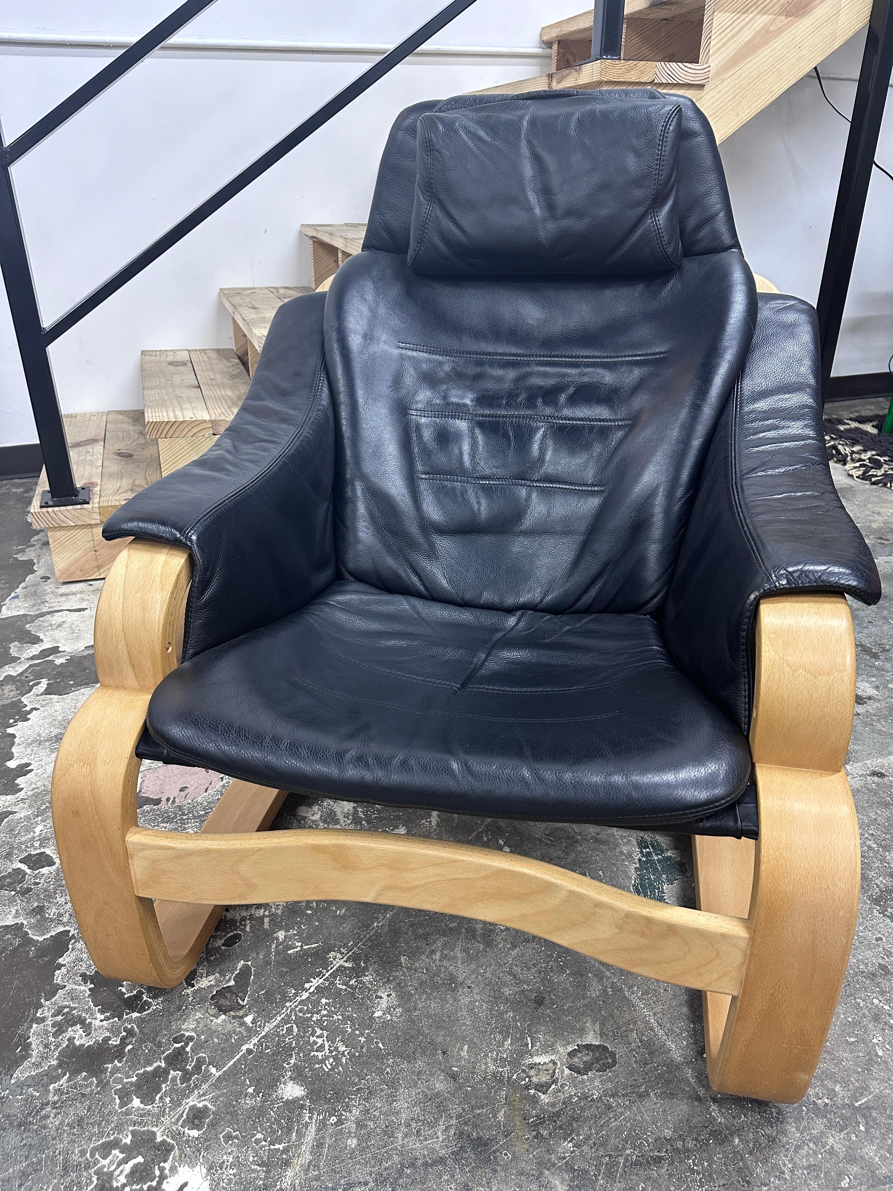 Dieser 'Apollo' Sessel besteht aus einem gebogenen Sperrholzrahmen und einer schwarzen Lederpolsterung. Es wurde in den 1970er Jahren von Skippers Furniture in Dänemark hergestellt und ist mit einem Label versehen. In ausgezeichnetem Vintage-Zustand