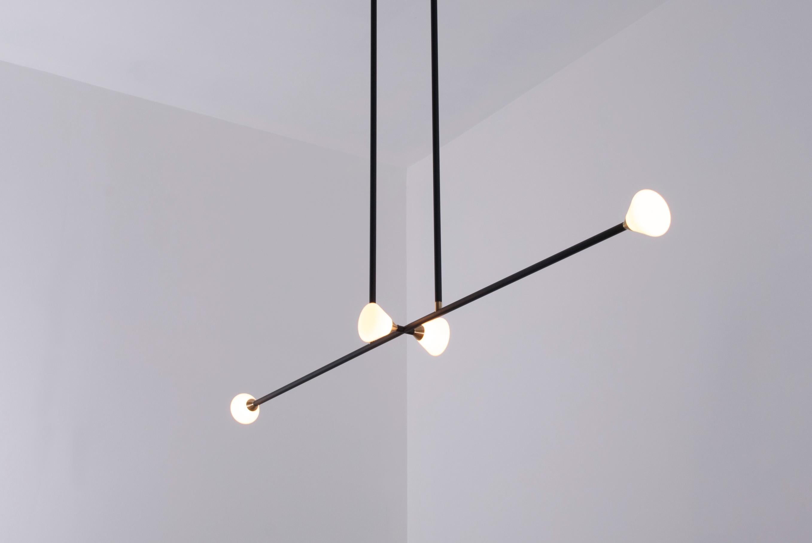 Opaque glass and brass shades seamlessly blend into a matte black armature. The Apollo four features four triangular shades in a balanced, double-stemmed luminary. The chandelier features a blackened oak canopy.

Our Apollo series chandeliers house