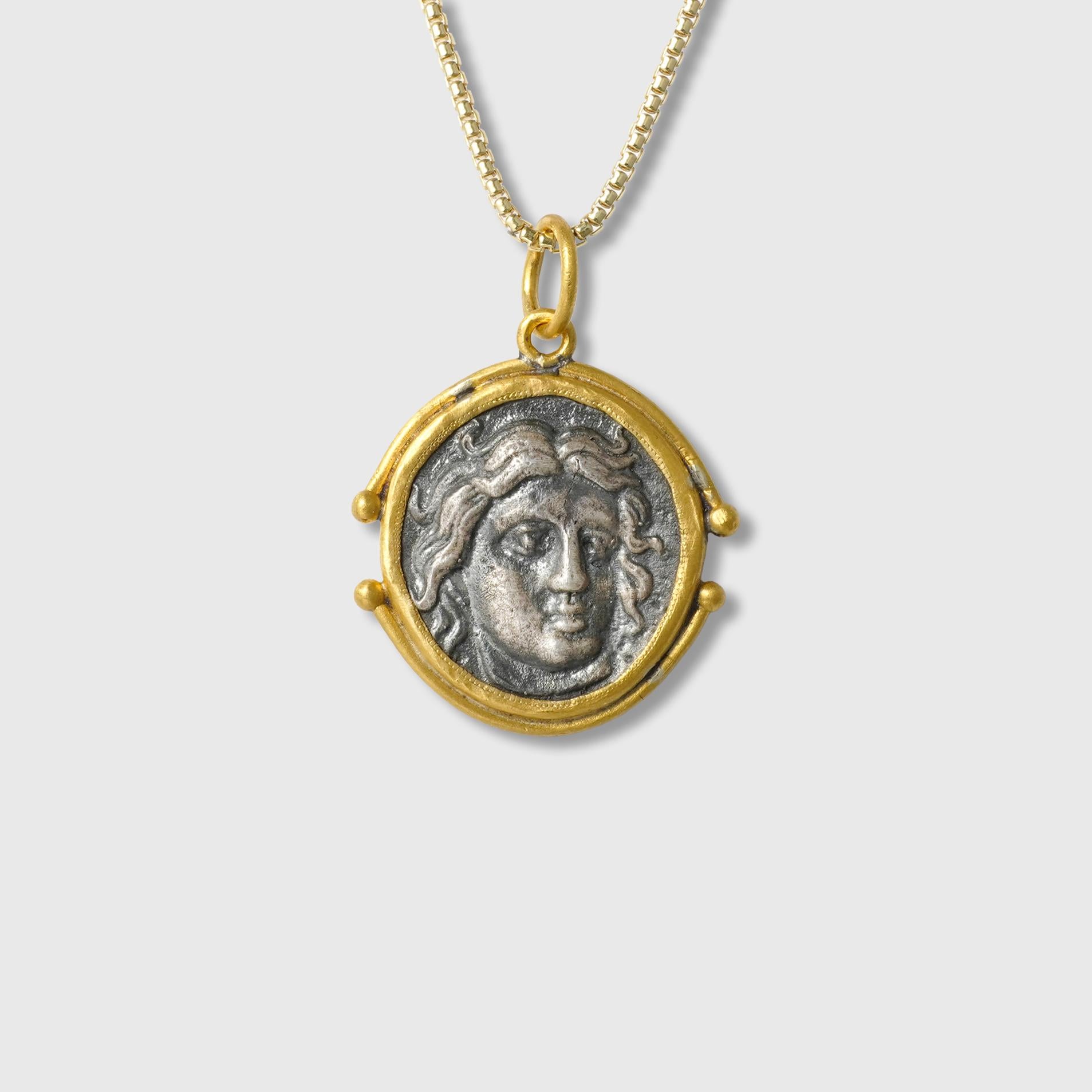 Pendentif en or et argent 24kt représentant Apollo, dieu des beaux-arts et de la musique - La face arrière montre la rose d'Apollo.

Apollo a été reconnu comme un dieu du tir à l'arc, de la musique et de la danse, de la vérité et de la prophétie, de