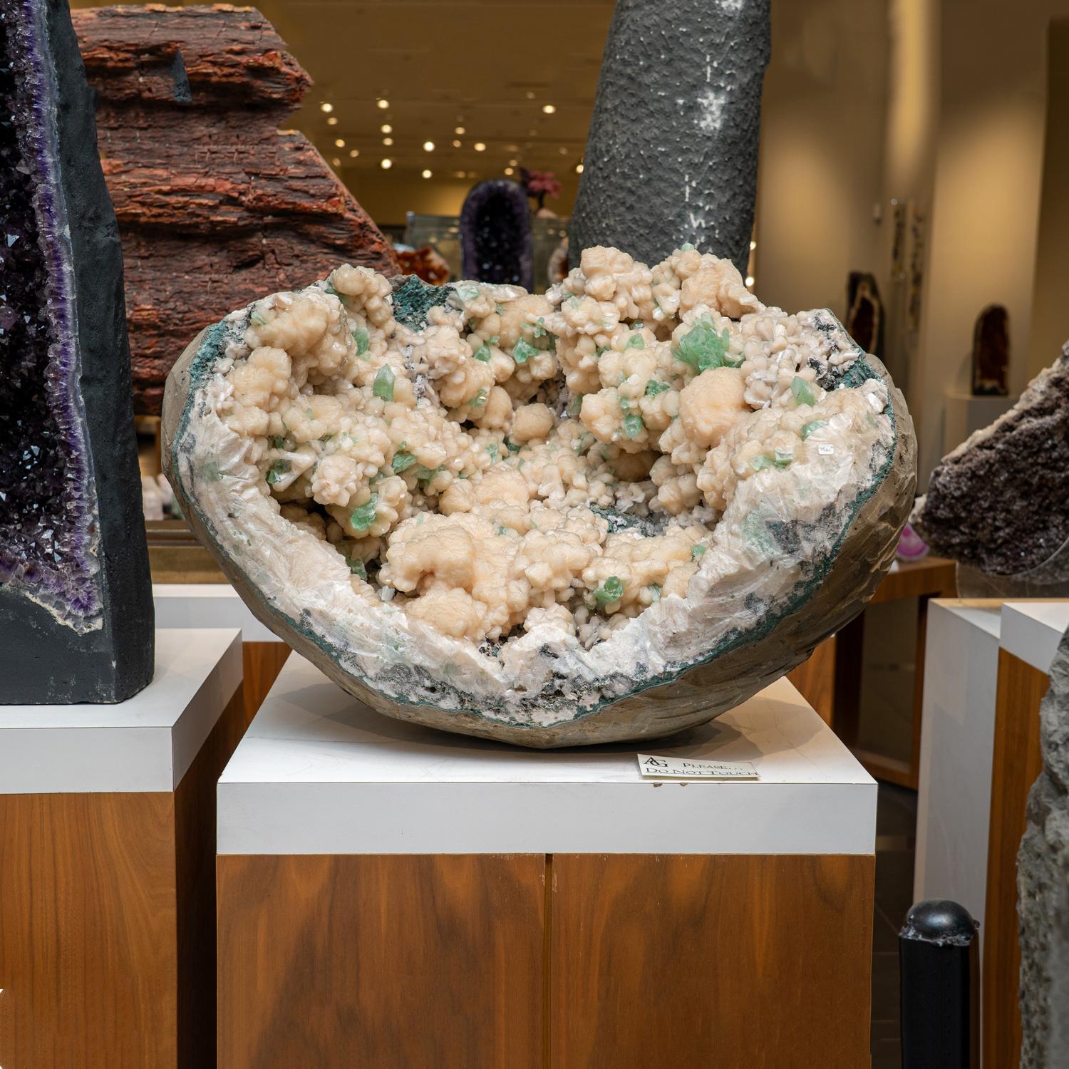 From Pashan Hill Quarry, Pune District, Maharashtra, India

Sparkling cluster of green apophyllite crystals in a radiating formation on matrix lined with creme-colored stilbite crystals in aggregates. The apophyllite crystals are fully terminated