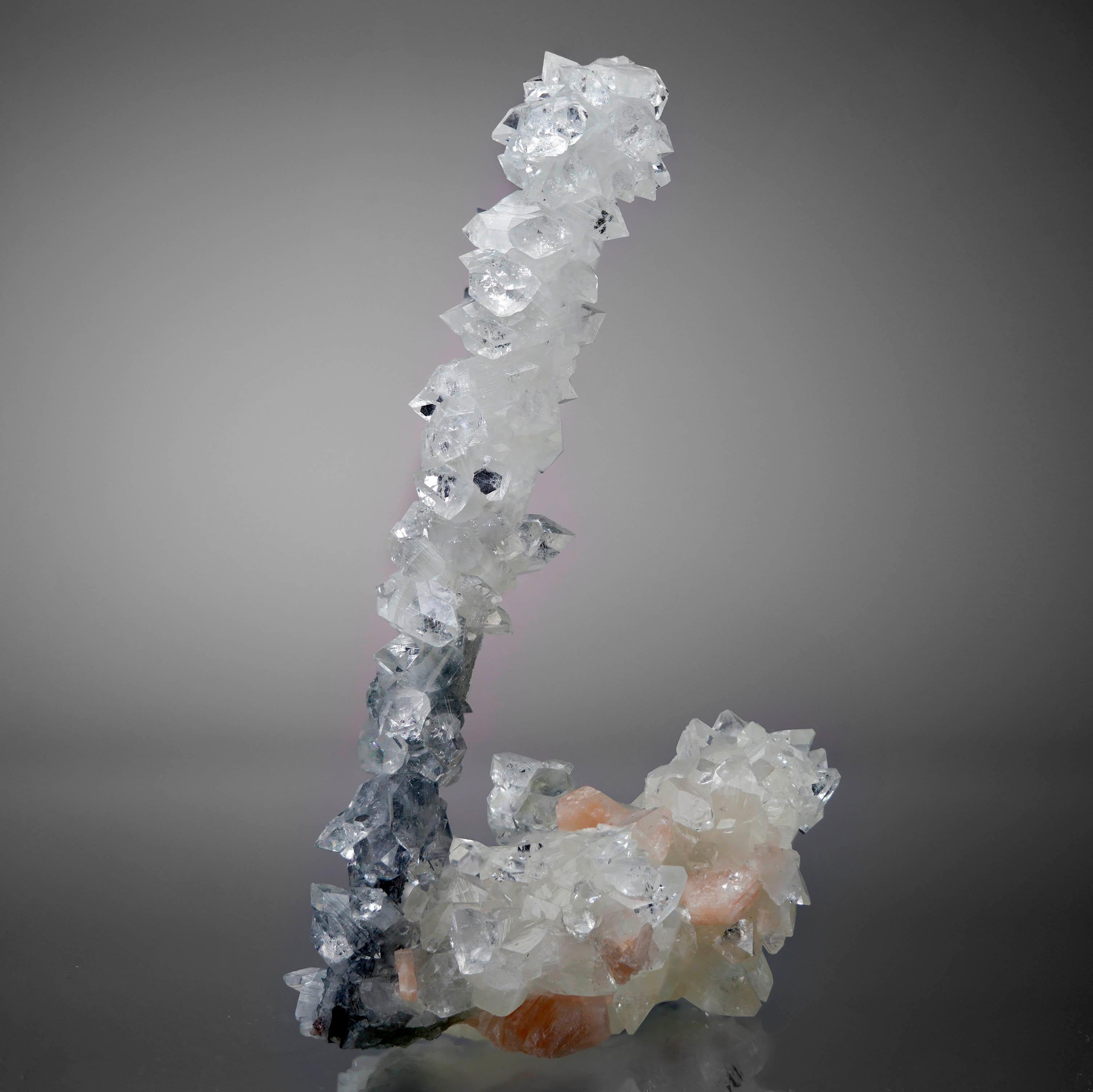 <p>An agate stalactite with druzy calcite, a pseudomorph of apophyllites, and a small accenting stilbite. The long dark agate growth beautifully transitions from calcite to apophyllites. A classic 