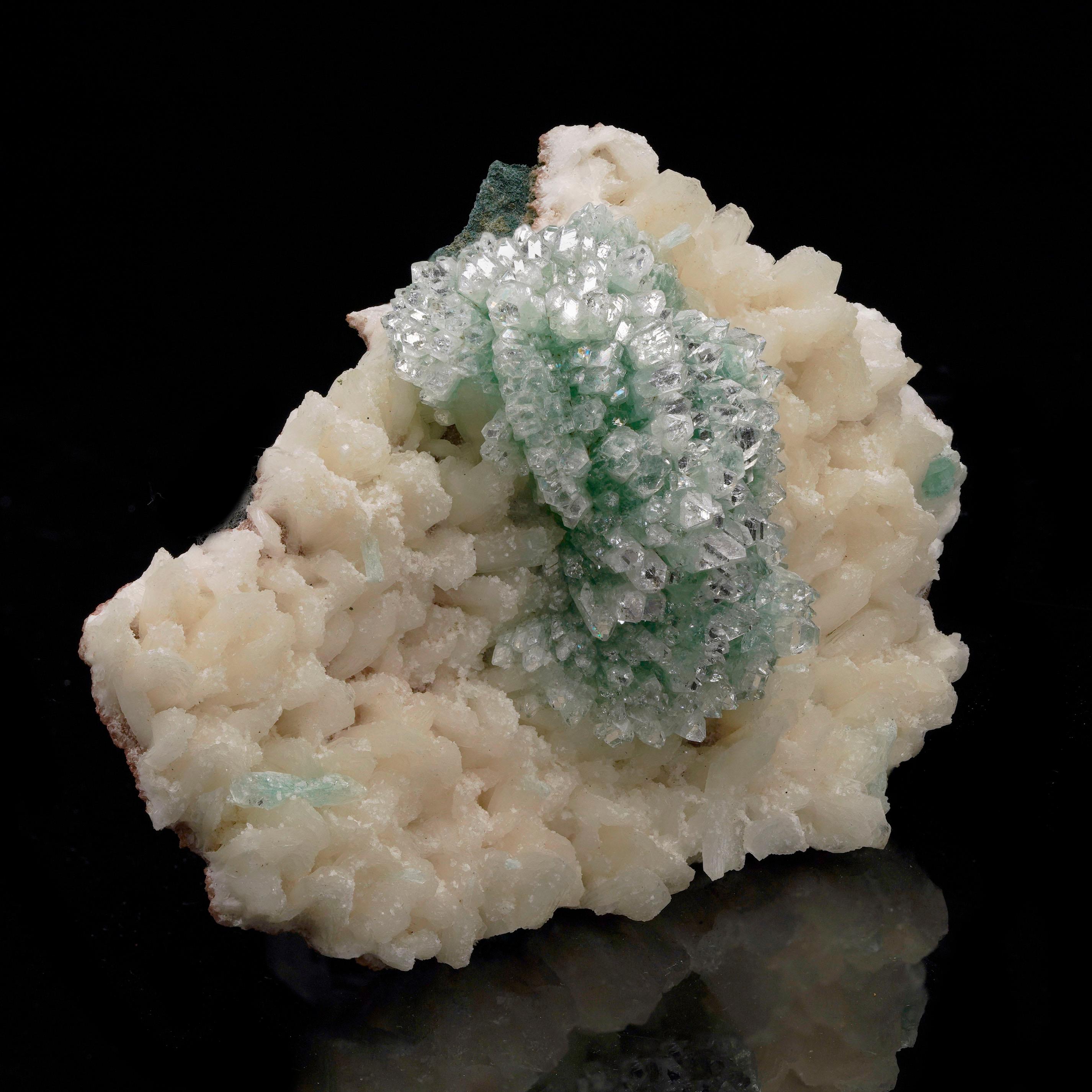 This eye-catching specimen from India features a brilliant Green Apophyllite cluster perfectly nestled atop a creamy matrix of Stilbite crystals. The Green Apophyllite radiates with sharp, glassy clarity, while the Stilbite adds a soft, pearlescent
