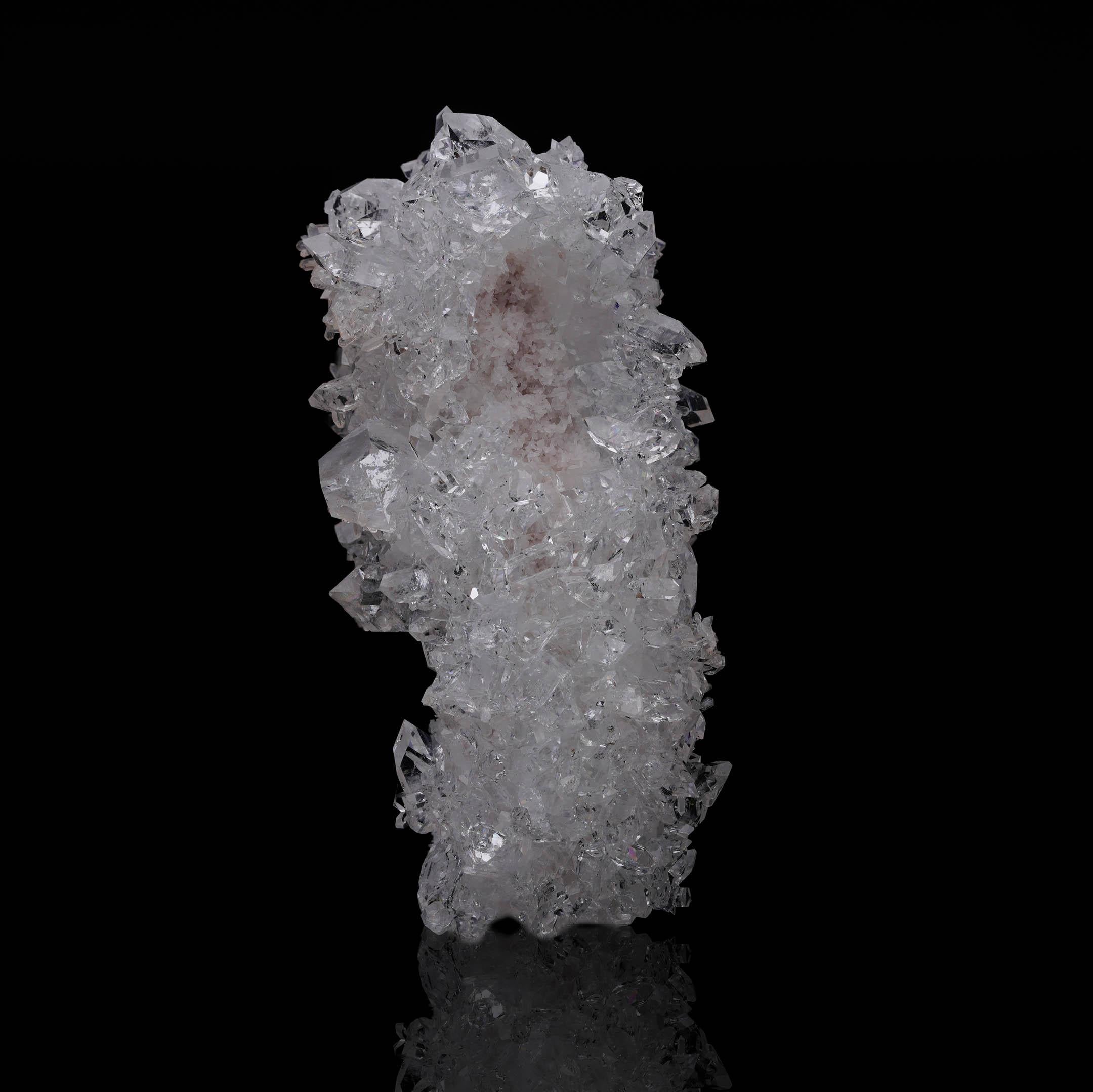 Esta excepcional estalactita de apofilita muestra una impresionante columna de cristales transparentes y vítreos dispuestos en una formación estalactítica natural. Procedente de las regiones ricas en minerales de la India, este fino ejemplar es un