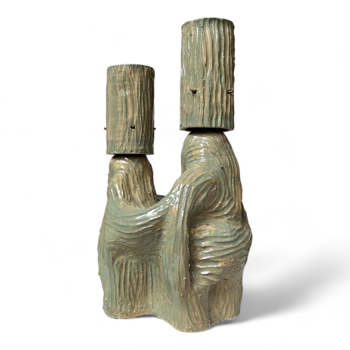 *Apostle & Muse, verde* (2022) de Rutger de Regt transforma una lámpara de mesa en una declaración escultórica. Fabricada en cerámica con un rico esmalte verde, la lámpara muestra las superficies texturadas características de De Regt, moldeadas por