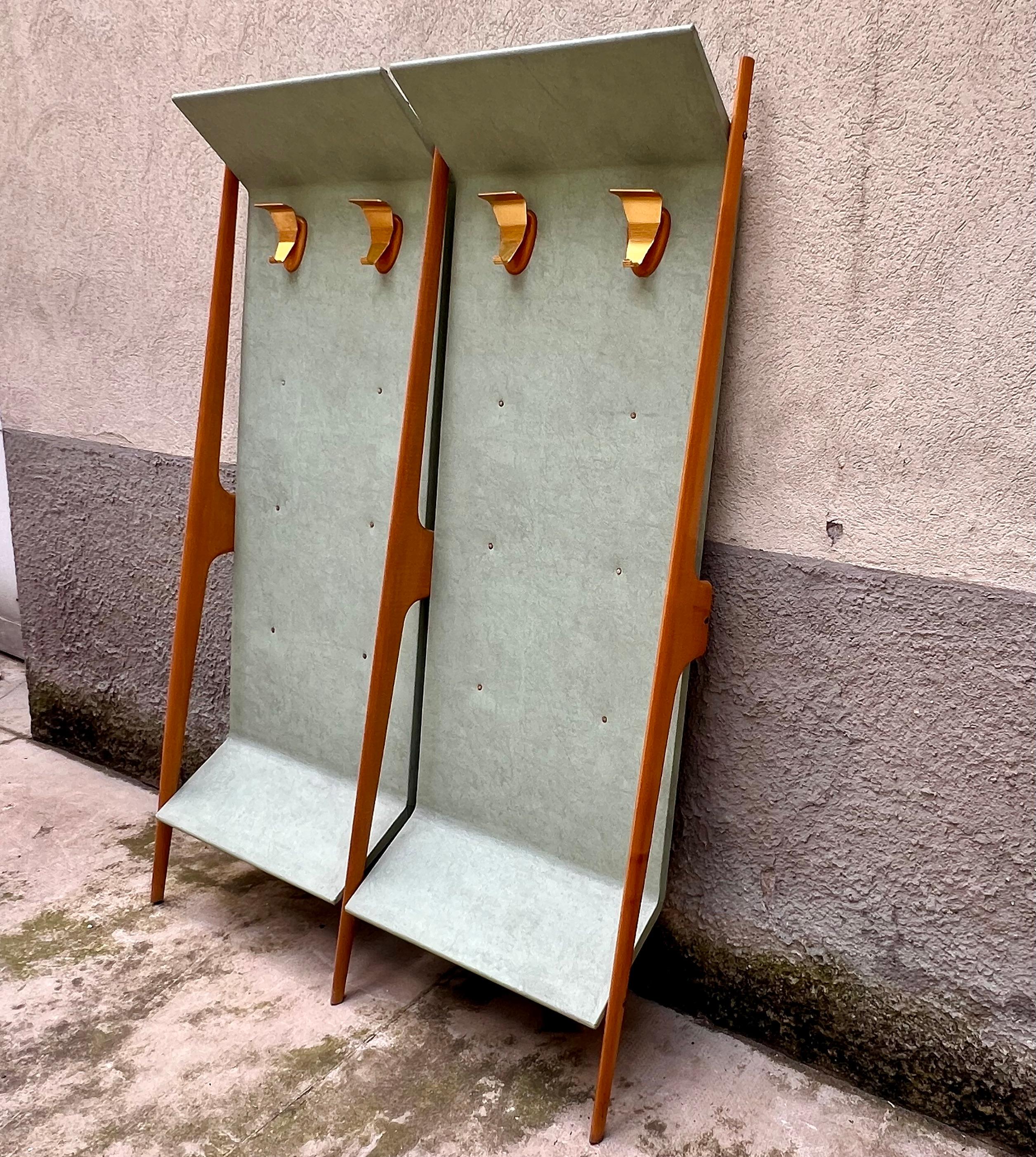 Elegante appendiabiti anni ‘50, perfetto per aggiungere un tocco di stile vintage alla tua casa. Realizzato in legno, questo pezzo presenta due pannelli inclinati rivestiti in vinile verde chiaro, con quattro robusti ganci in alluminio zapponato,
