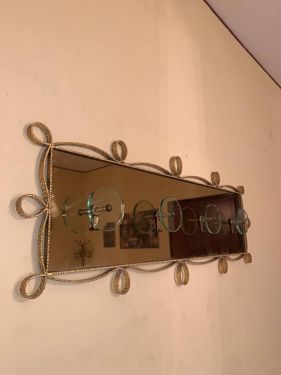 Elegant and fine handcrafted brass coat stand, gold-colored mirrored glass, made by Pierluigi Colli, 1950s. Including rectangular glass on top. Presence of two round patinas on the glass, caused by 'wear and tear of time.. Upper glass support