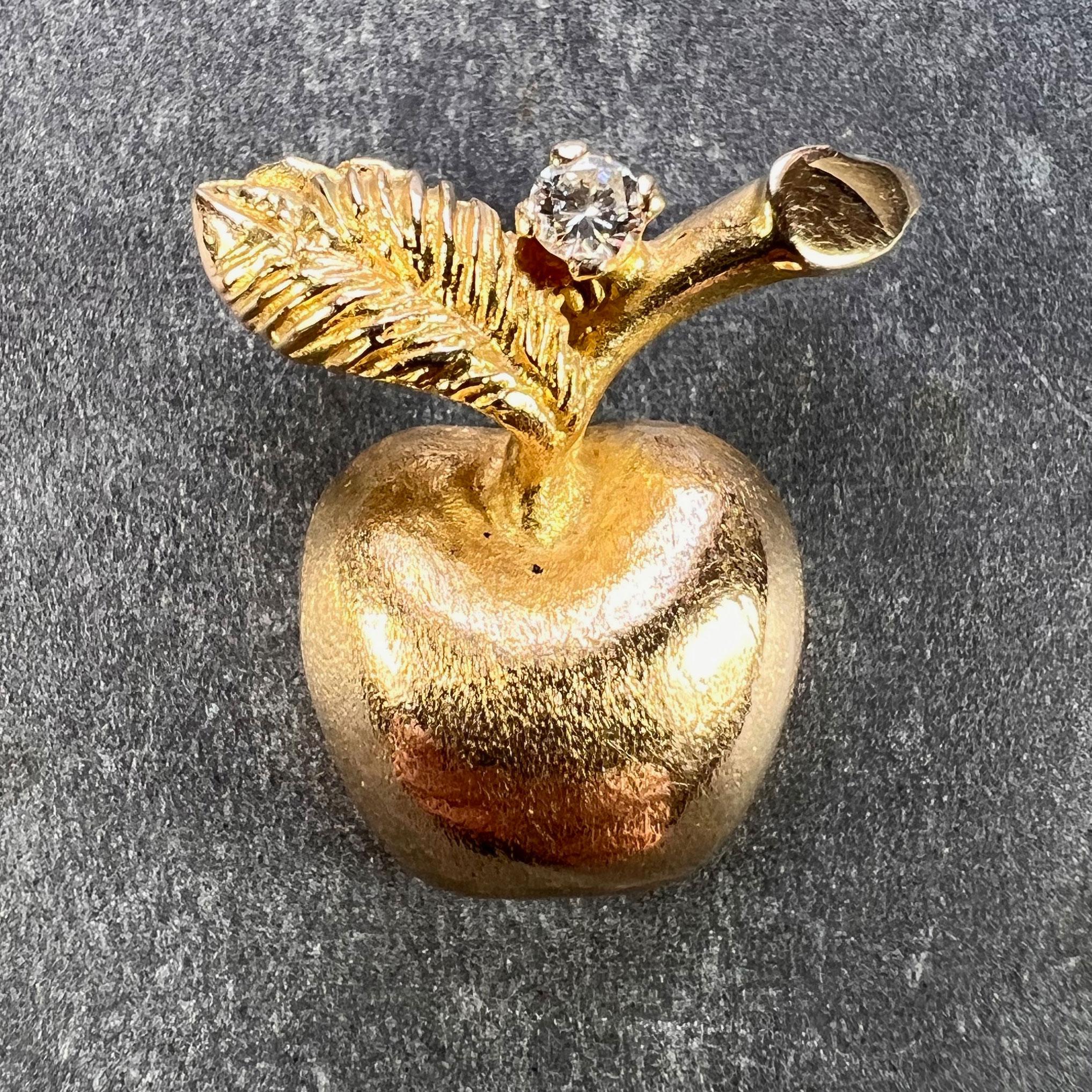 A 14 karat (14K) yellow gold fruit charm pendant designed as an apple set with a round brilliant cut diamond (approximately 0.10 carats, F-G colour, VS clarity - not unmounted for grading) to the stem. Marked 585 for 14 karat gold to the back of the