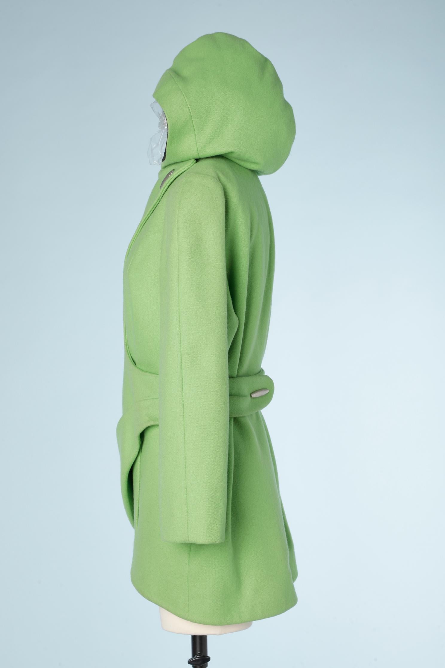Apple green wool wrapped jacket with hood.  Silver metal details on the belt ( in the middle back with a snap underneath) and in the middle front. ( same with a snap underneath)

The color is brighter in reality than on the picture.
SIZE : 42 ( It)