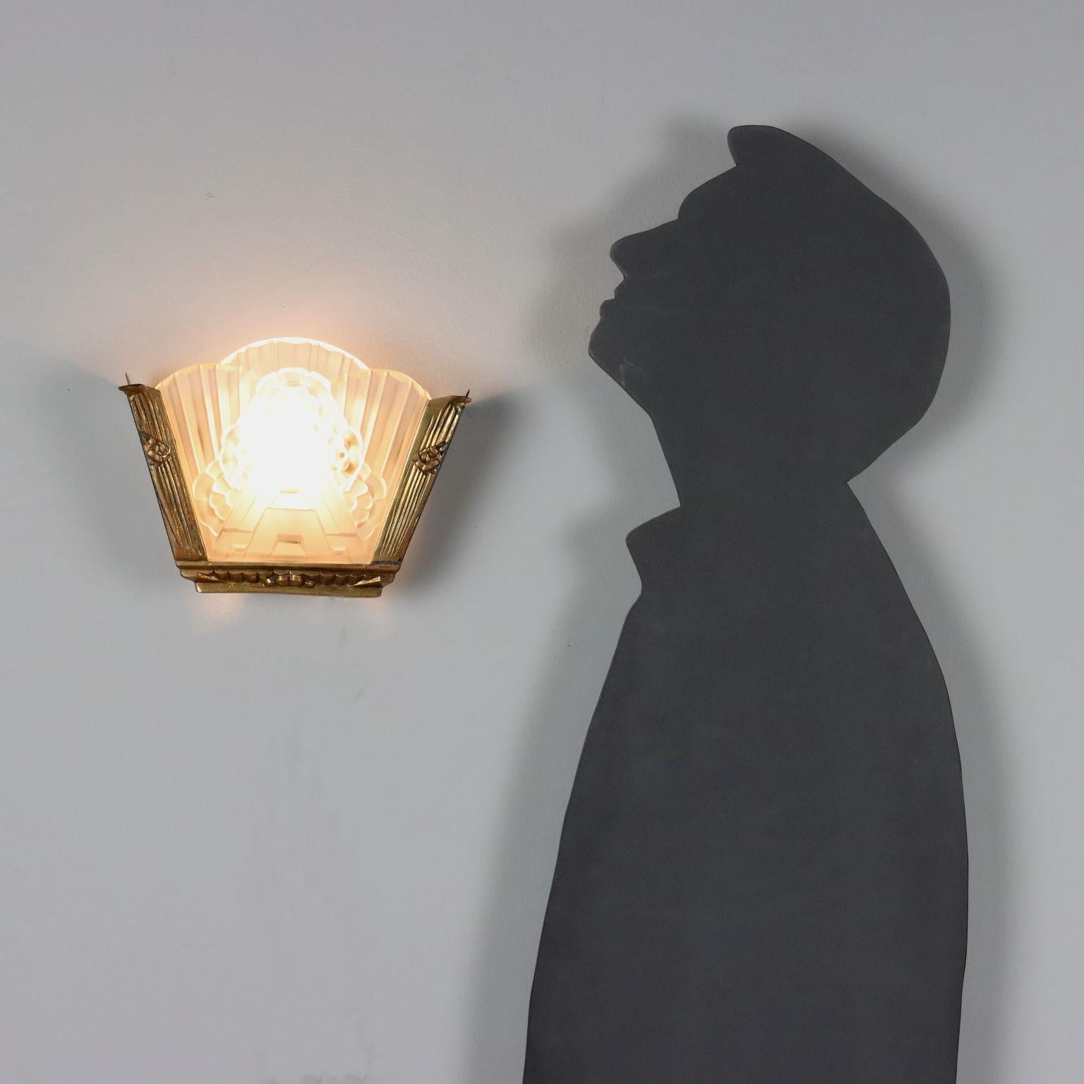 Elegante lampada a parete vintage con struttura in ottone e vetro lavorato.
