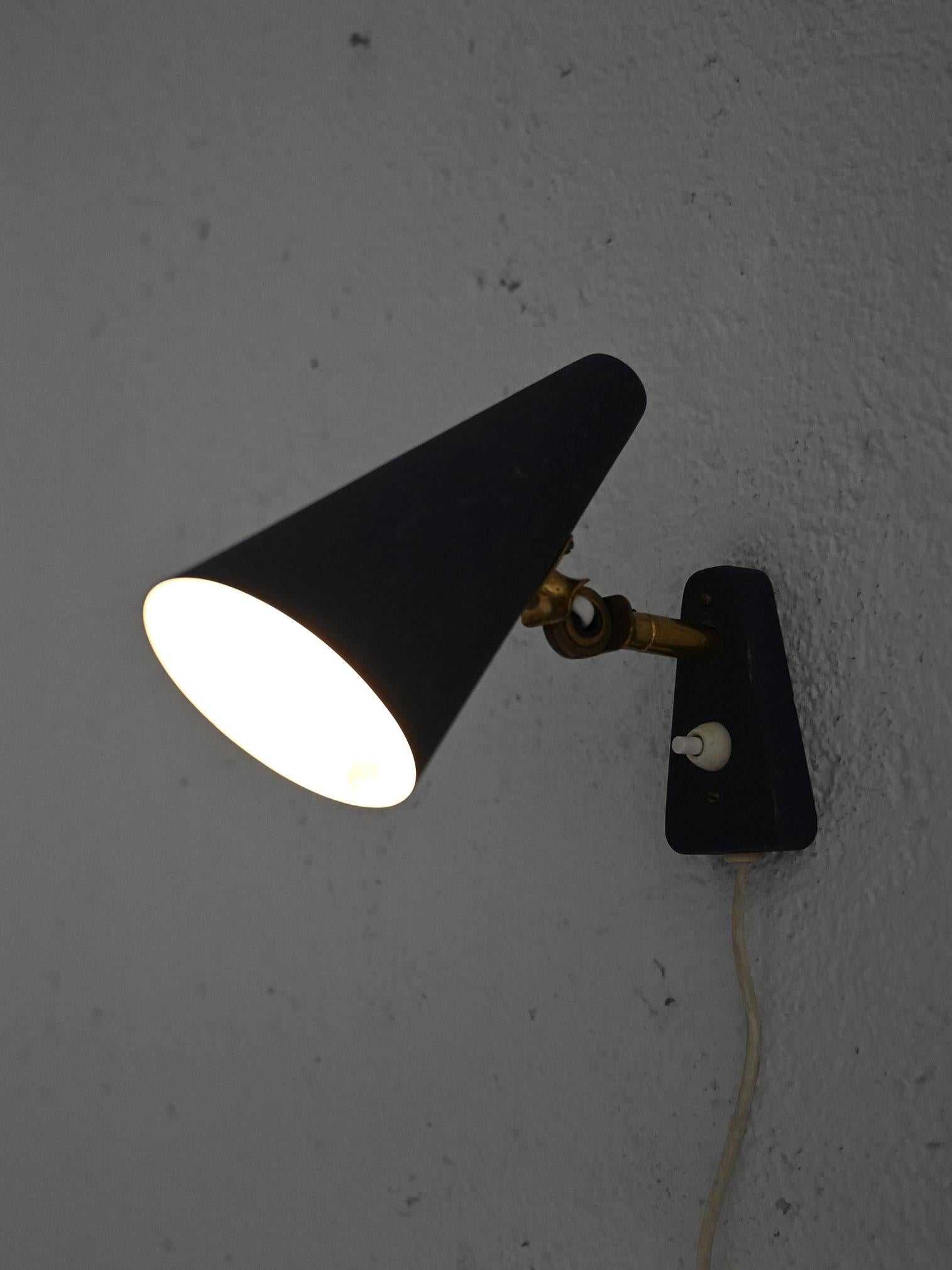 Aplique vintage con pantalla cónica azul y detalles de latón. Es perfecta para quienes buscan una iluminación elegante con un toque vintage.

La pantalla es cónica y de metal azul mate, típica del diseño de los años cincuenta y sesenta. La base de