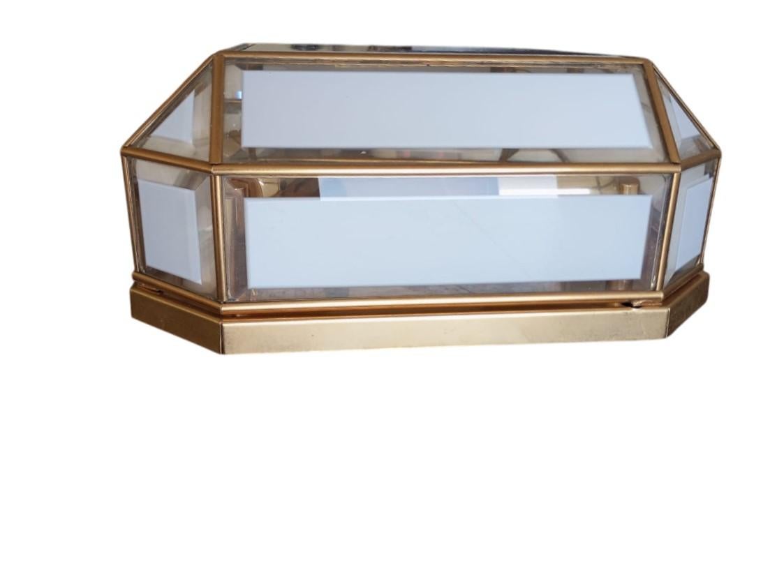 
Elegante applique da parete in stile geometrico, risalente all’Italia degli anni ’70. La struttura è a base quadrata (30 x 30 cm) con una profondità di 15 cm, ed è dotata di quattro punti luce interni.
Il design presenta una composizione con vetri
