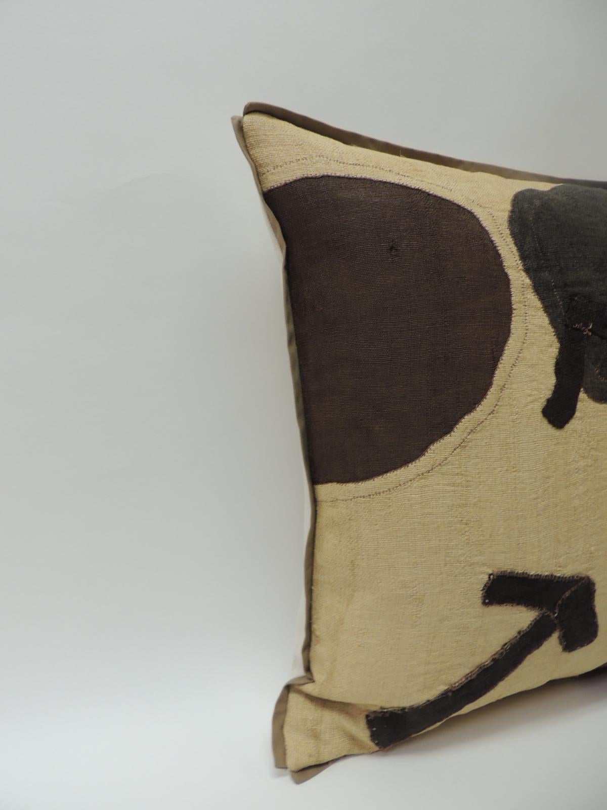 Applique raffia, patchwork and applique brown, black and natural decorative pillow with,
custom flat cotton trim in earth-tone khaki color all around. Natural cotton and linen backing. Pillow handcrafted and designed in the USA with custom made