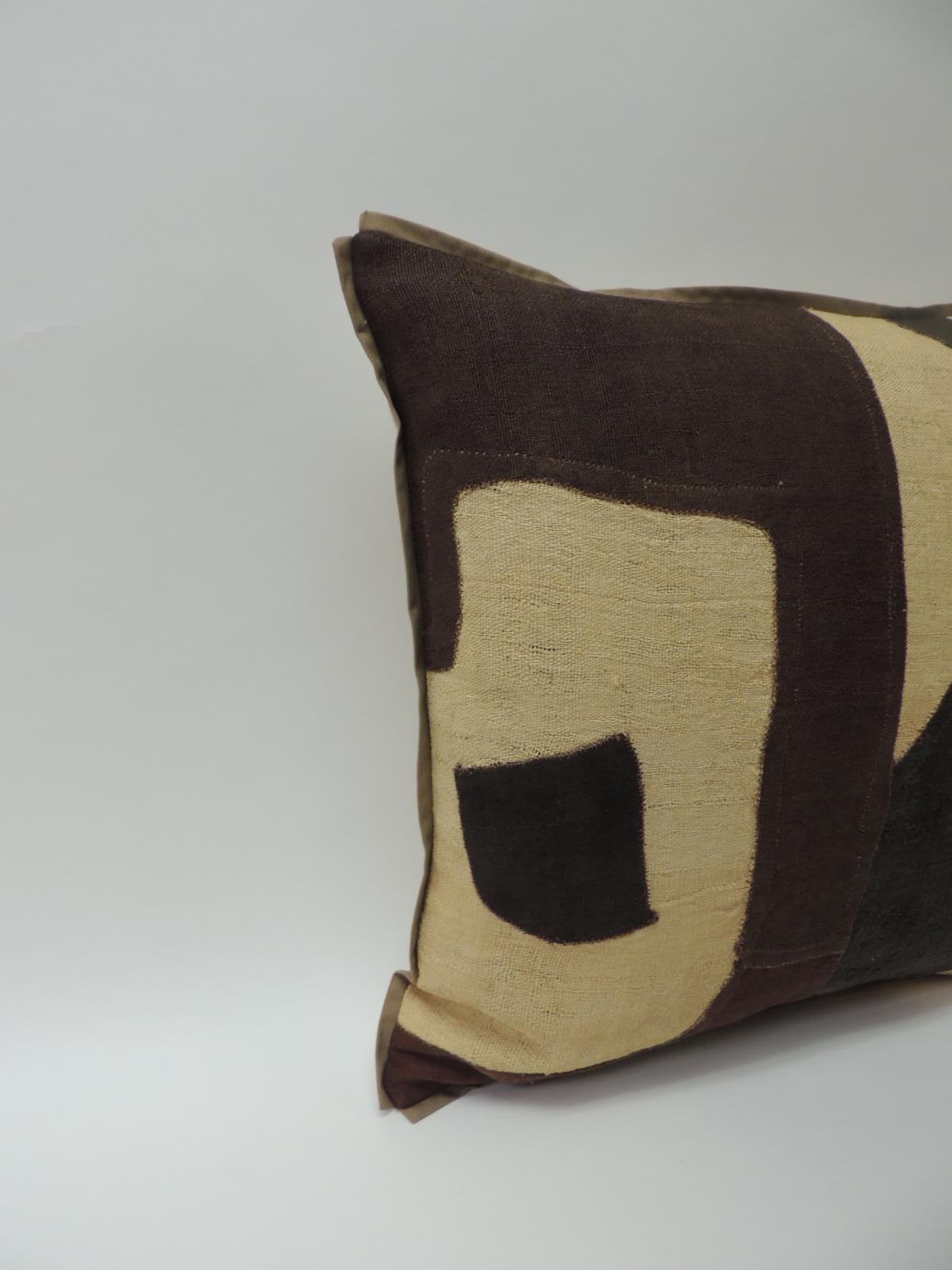 Applique raffia, patchwork and applique brown, black and natural decorative pillow with
custom flat cotton trim in earth-tone khaki color all around. Natural cotton and linen backing. Pillow handcrafted and designed in the USA with custom made