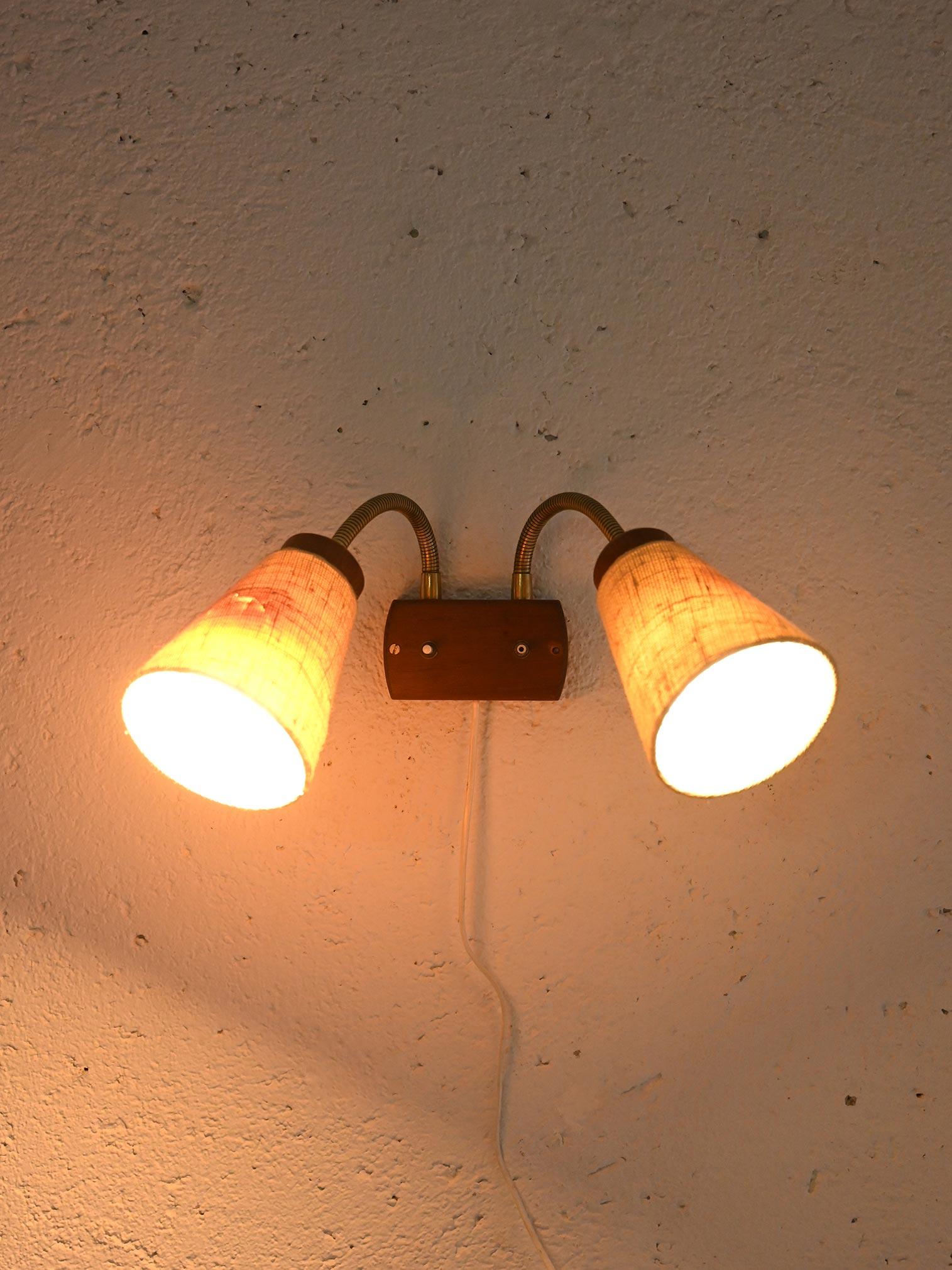 Lampada vintage scandinava con due paralumi conici in tessuto chiaro e braccio dorato direzionabile.

I paralumi sono in tessuto tessuto chiaro color sabbia e diffondono una luce morbida. Il braccio flessibile in metallo permette di orientare le