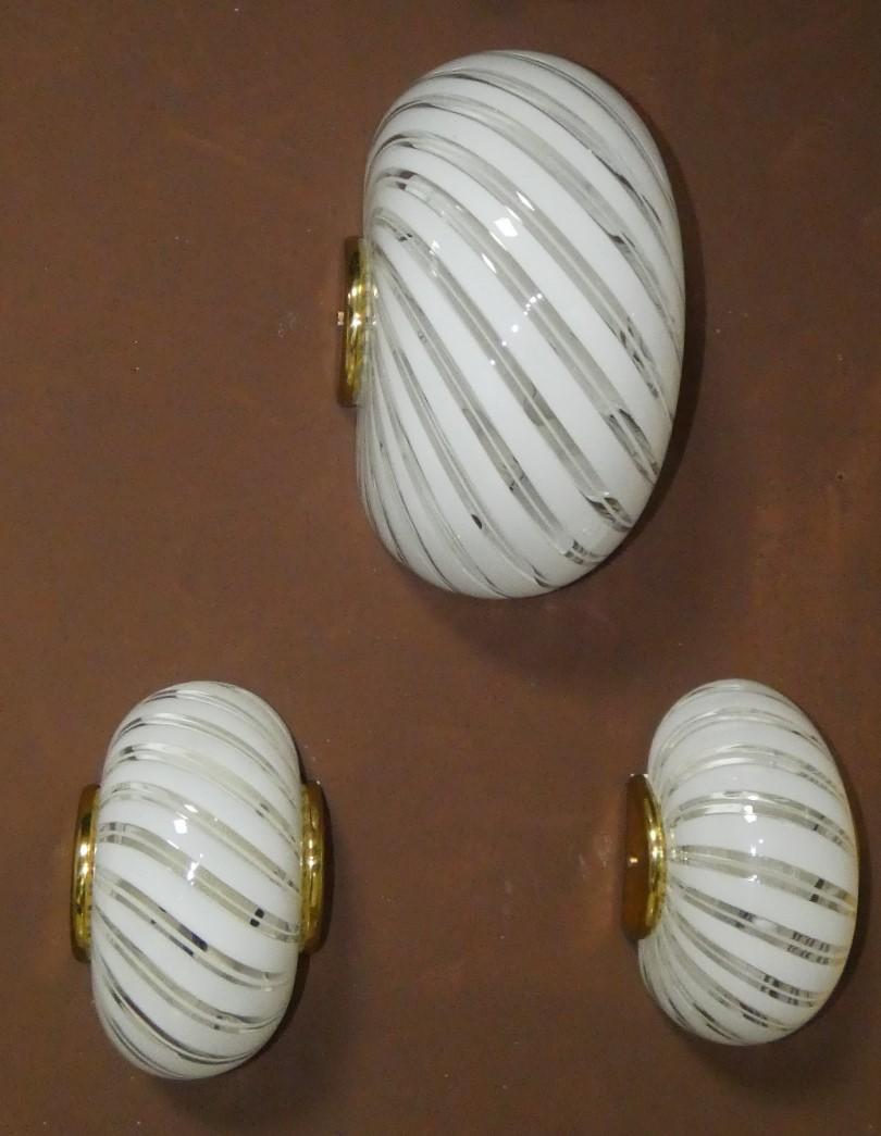 Set di Tre Appliques di Fabbian, anni '80, prodotte in Italia e realizzate in Vetro di Murano e Ottone.
Il set è composto da una applique grande e due appliques più piccole.
Lampade da parete molto eleganti e minimaliste. Le lampade sono in ottime