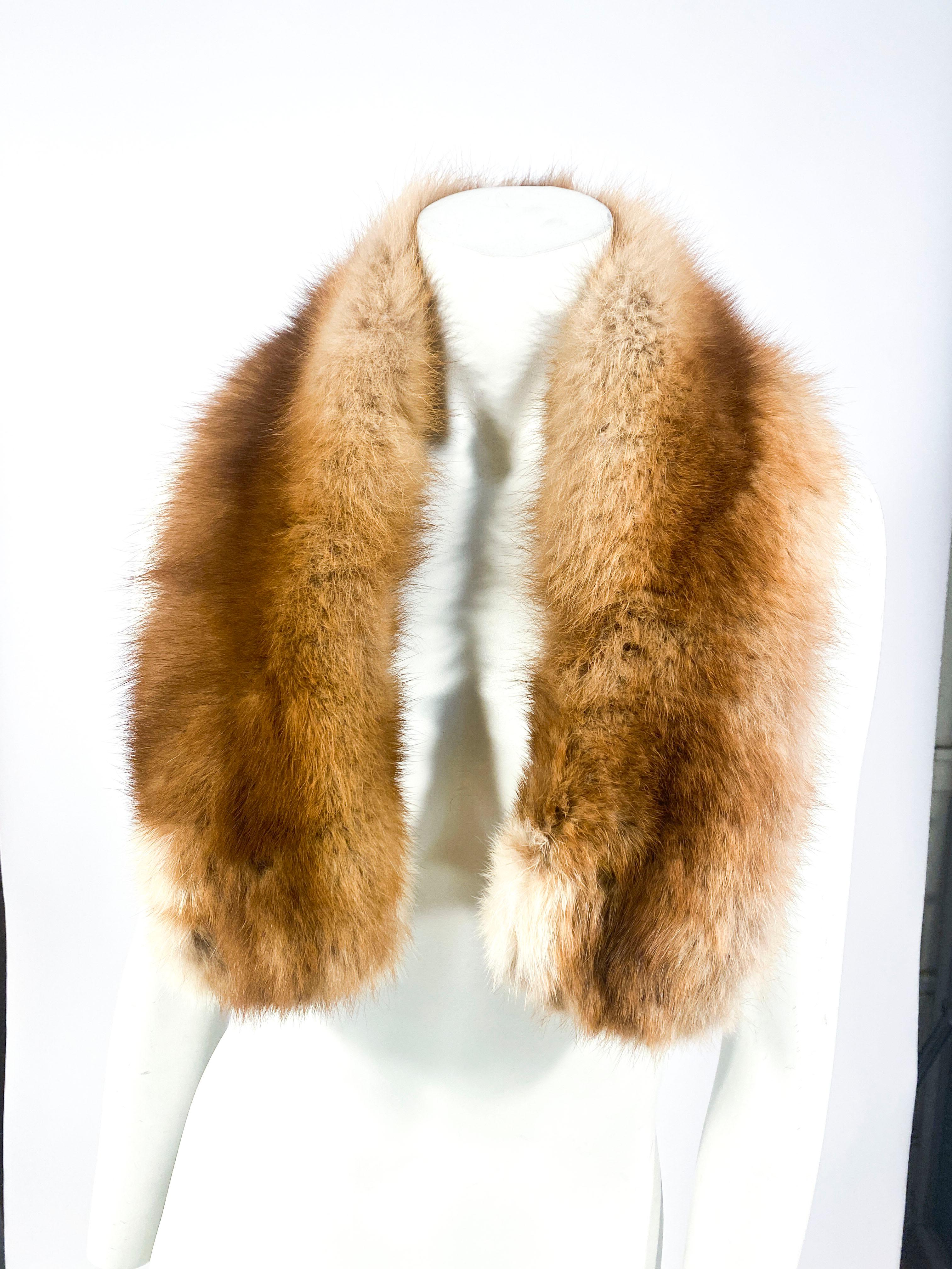 Apricot colored nutria fur that may be worn as a scarf or an enlarged collar. The piece is lined with brown velvet and are detached a places for a holder and has traditional collar clips. 
