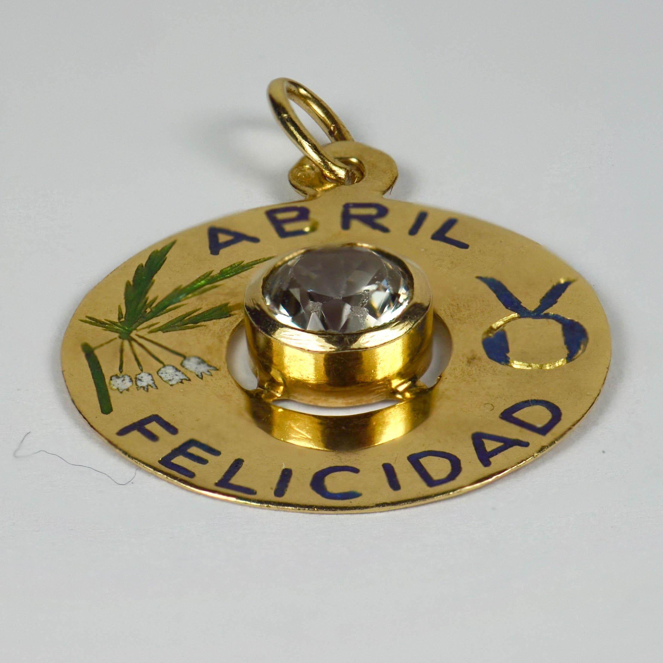 An 18 karat yellow gold charm pendant designed as a gold disc with enamel inlay of 'ABRIL FELICIDAD' (April Happiness) with the zodiac symbol for Taurus and lily of the valley (meaning happiness or joy) in enamel, and set to the centre with a