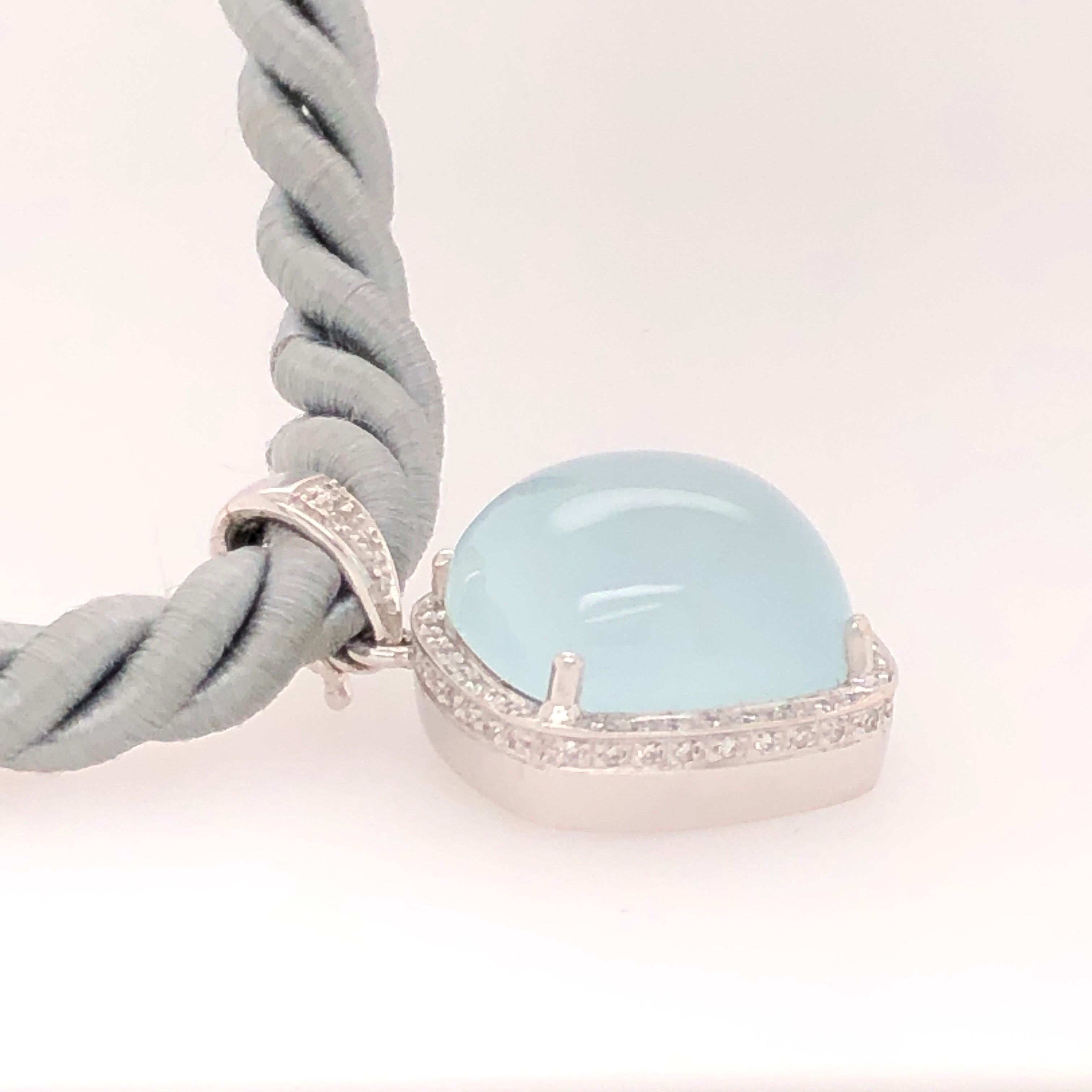 This luminescent aqua chalcedony is set in to a 14K white gold pendant. A sparkle of 0.25 CTS of diamonds sit in a halo around the stone. 

Signed: Rina Limor 

From the Skibell Estate Collection