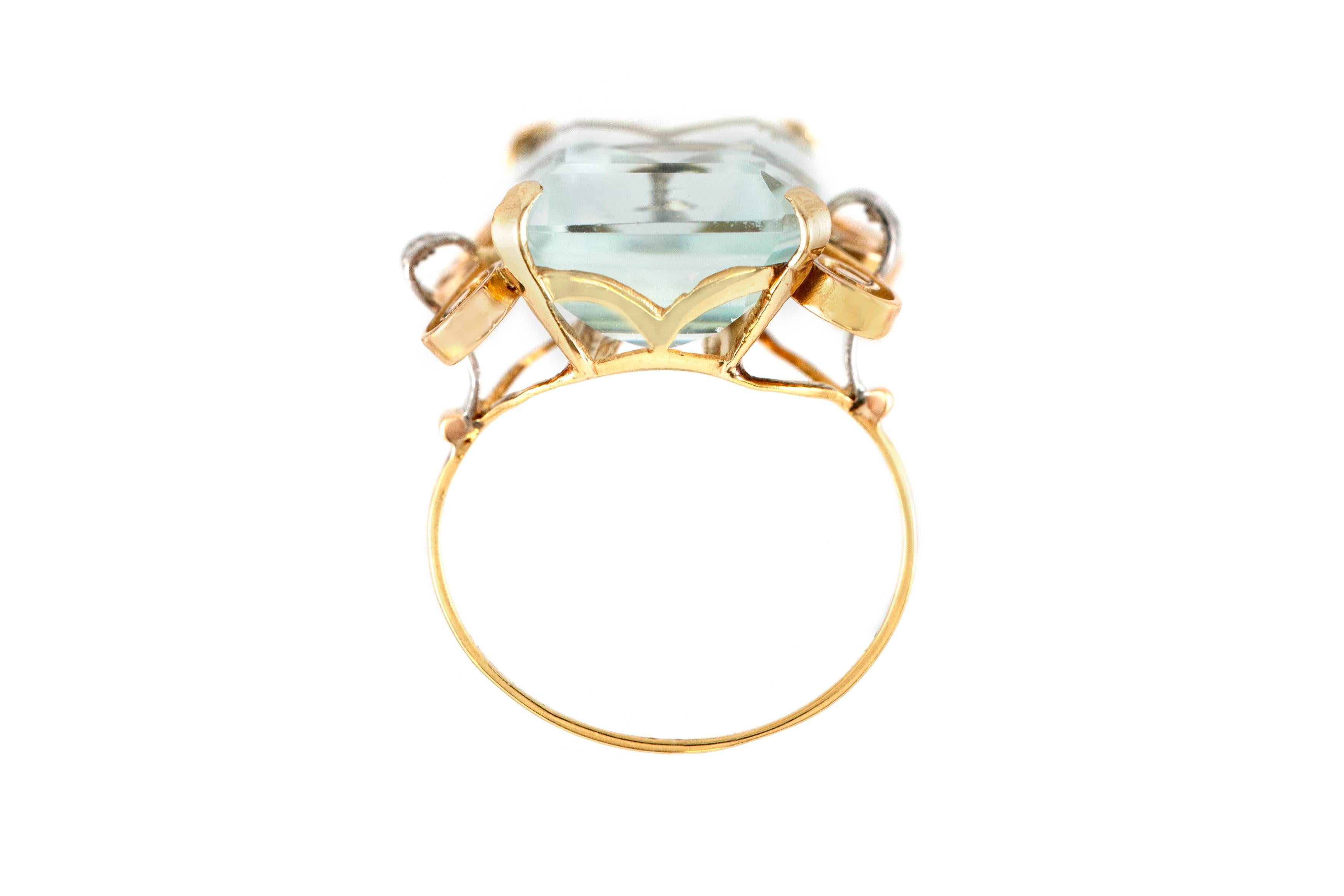 The ring is finely crafted in 18k yellow gold with two small diamonds on the sides and one aquamarine center stone weighing approximately total of 25.00 carat.